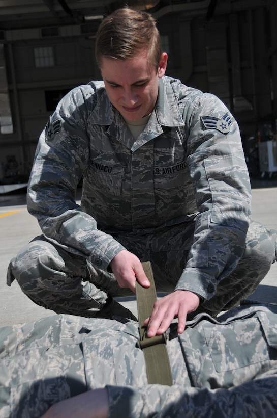 Senior Airman Christopher Iennaco of the 104th Fighter Wing tightens the straps on the litter to ensure his patient is secure prior to boarding an HH-60 medevac during the  Joint Medic augmentee training. Airmen from the 104th Fighter Wing brought their medical skills on board to familiarize themselves with flying while carrying out their medical duties. The 104th Fighter Wing medics and the Det 1 C Company 3-126 Aviation flight medics trained together on flight medic procedures for in route patient care in support of domestic operations for the state of Massachusetts. (Air National Guard Photo by Master Sgt. Julie Avey)