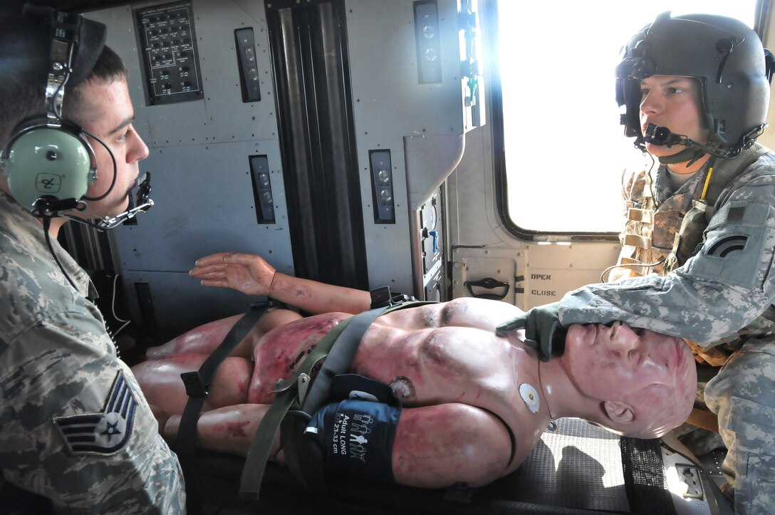 Sgt. Brad Demers, flight medic for the Massachusetts Army National Guard, 3-126th Aviation, instructs Senior Airman Anthony Fappiano, medic from the Massachusetts Air National Guard, 104th Fighter Wing, 104th Medical Group, on flight medic procedures and in route patient care on board the HH-60 Medevac Black Hawk during joint medic augmentee training at Barnes Air National Guard Base. Airmen from the 104th Fighter Wing brought their medical skills on board to familiarize themselves with flying while carrying out their medical duties. The 104th Fighter Wing and the Det 1 C Company 3-126th Aviation teamed up to increase flight medics in support of domestic operations.  The Joint Medic augmentee training will enhance and increase medical capabilities for domestic operations during search and rescues, emergency disaster responses, and statewide events such as the Boston Marathon.(U.S. Air National Guard Photo by Master Sgt. Julie Avey)  