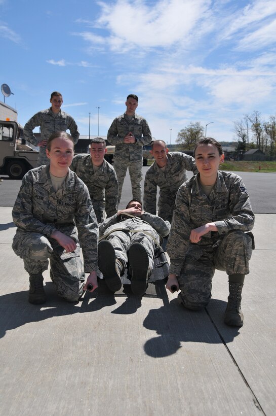 Senior Airman Courtney Greene, left front, Senior Airman Kelley Mclean, right front, Staff Sgt. Anthony Fappiano, and Senior Airman Justin Gilbert, right back, of the 104th Fighter Wing, prepare to load a patient on board a HH-60 medevac  during the Barnes Air National Guard Base Air and Army National Guard Joint Medic augmentee training.  The Joint Medic augmentee training will enhance and increase the number of medics available for domestic operations during search and rescues, emergency disaster responses, and statewide events such as the Boston Marathon.(U.S. Air National Guard Photo by Master Sgt. Julie Avey)  