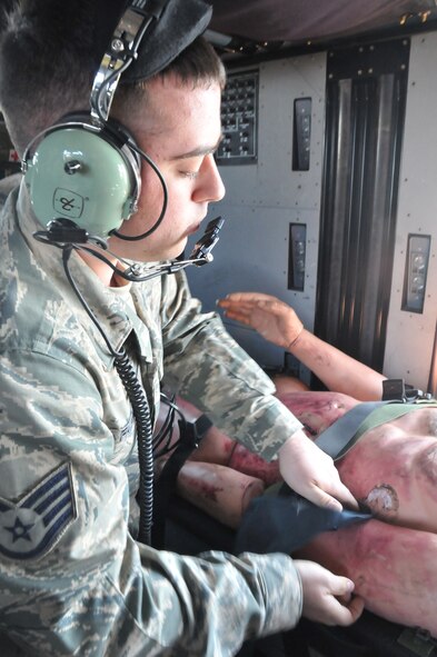 Senior Airman Anthony Fappiano of the 104th Fighter Wing, provides in route emergency care for his patient on board a HH-60 medevac during Joint Medic augmentee training at Barnes Air National Guard Base. The 104th Fighter Wing medics and the Det 1 C Company 3-126 Aviation flight medics trained together on flight medic procedures for in route patient care in support of domestic operations for the state of Massachusetts. (Air National Guard Photo by Master Sgt. Julie Avey)