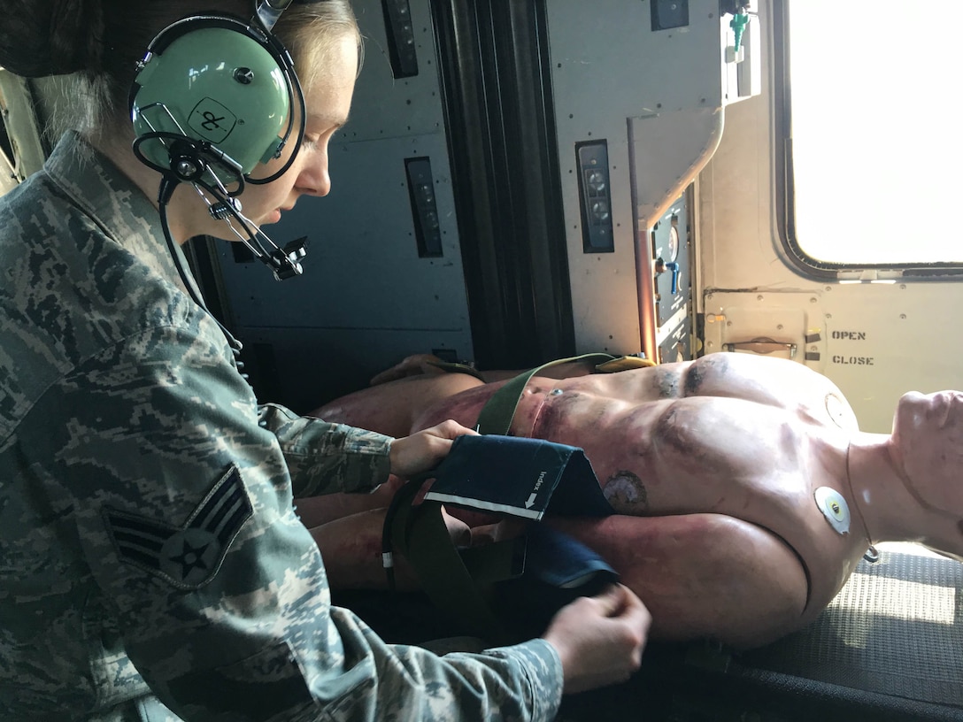 Senior Airman Courtney Greene of the 104th Fighter Wing provides in route emergency patient care on board the  HH-60 medevac during Joint Medic augmentee training at Barnes Air National Guard Base. Airmen from the 104th Fighter Wing brought their medical skills on board to familiarize themselves with flying while carrying out their medical duties. The 104th Fighter Wing medics and the Det 1 C Company 3-126 Aviation flight medics trained together on flight medic procedures for in route patient care in support of domestic operations for the state of Massachusetts. (Air National Guard Photo by Master Sgt. Julie Avey)