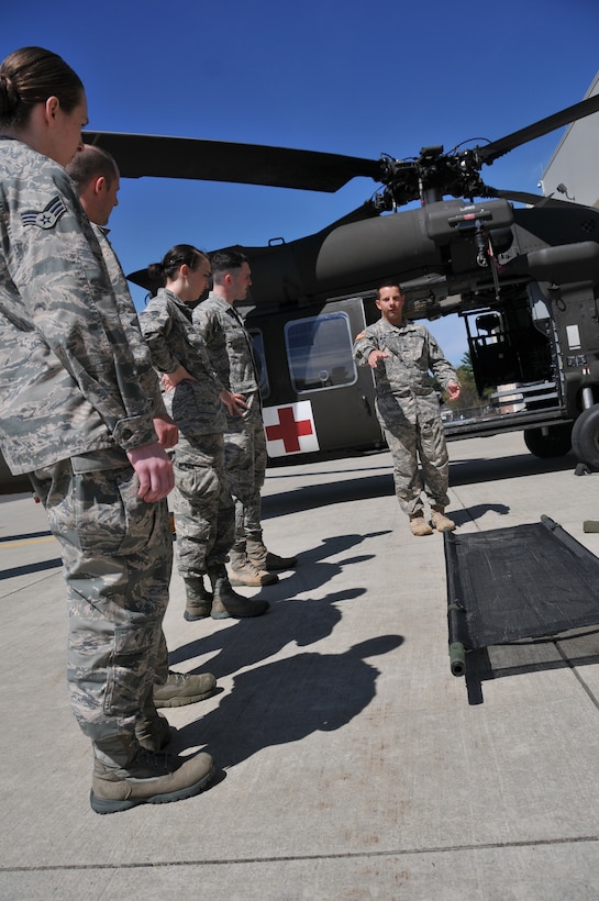 Sgt. Brad Demers, flight medic for the Massachusetts Army National Guard, 3-126th Aviation, instructs medics from the Massachusetts Air National Guard, 104th Fighter Wing, 104th Medical Group, on hot loading patients and approaching the HH-60 Medevac BlackHawk aircraft from the three o' clock position safely clearing the blades, during joint medic augmentee training at Barnes Air National Guard Base. The 104th Fighter Wing and the Det 1 C Company 3-126th Aviation teamed up to increase flight medics in support of domestic operations.  The Joint Medic augmentee training will enhance and increase medical capabilities for domestic operations during search and rescues, emergency disaster responses, and statewide events such as the Boston Marathon.(U.S. Air National Guard Photo by Master Sgt. Julie Avey)  