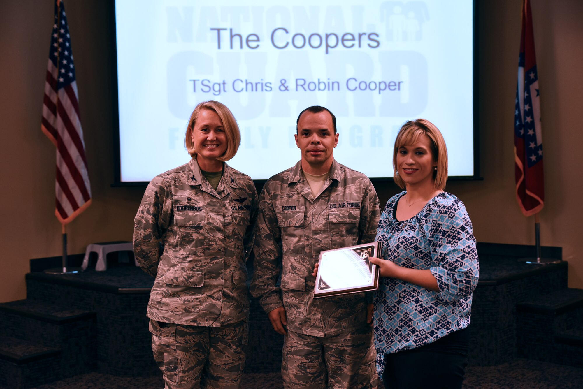 Tech. Sgt. Christopher Cooper, 188th Logistics Readiness Squadron member, and his wife receive the 2016 Arkansas National Guard Family of the Year Award from Col. Bobbi Doorenbos, 188th Wing commander, May 15, 2016, during commander’s call at Ebbing Air National Guard Base, Fort Smith, Ark. Cooper and his family have shown outstanding service by completing 166 volunteer hours since 2012. (U.S. Air National Guard photo by Senior Airman Cody Martin/Released)