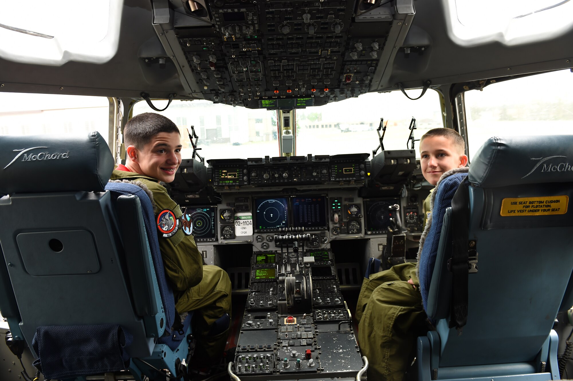Daniel Duffy (left) and Nicholas Duffy (right) sit in the cock pit of a C-17 Globemaster III at Joint Base Lewis-McChord, Wash., May 26, 2016. The brothers are the newest Pilots for a Day here at McChord and were welcomed as honorary members of the 4th Airlift Squadron. (U.S. Air Force photo/Staff Sgt. Naomi Shipley)