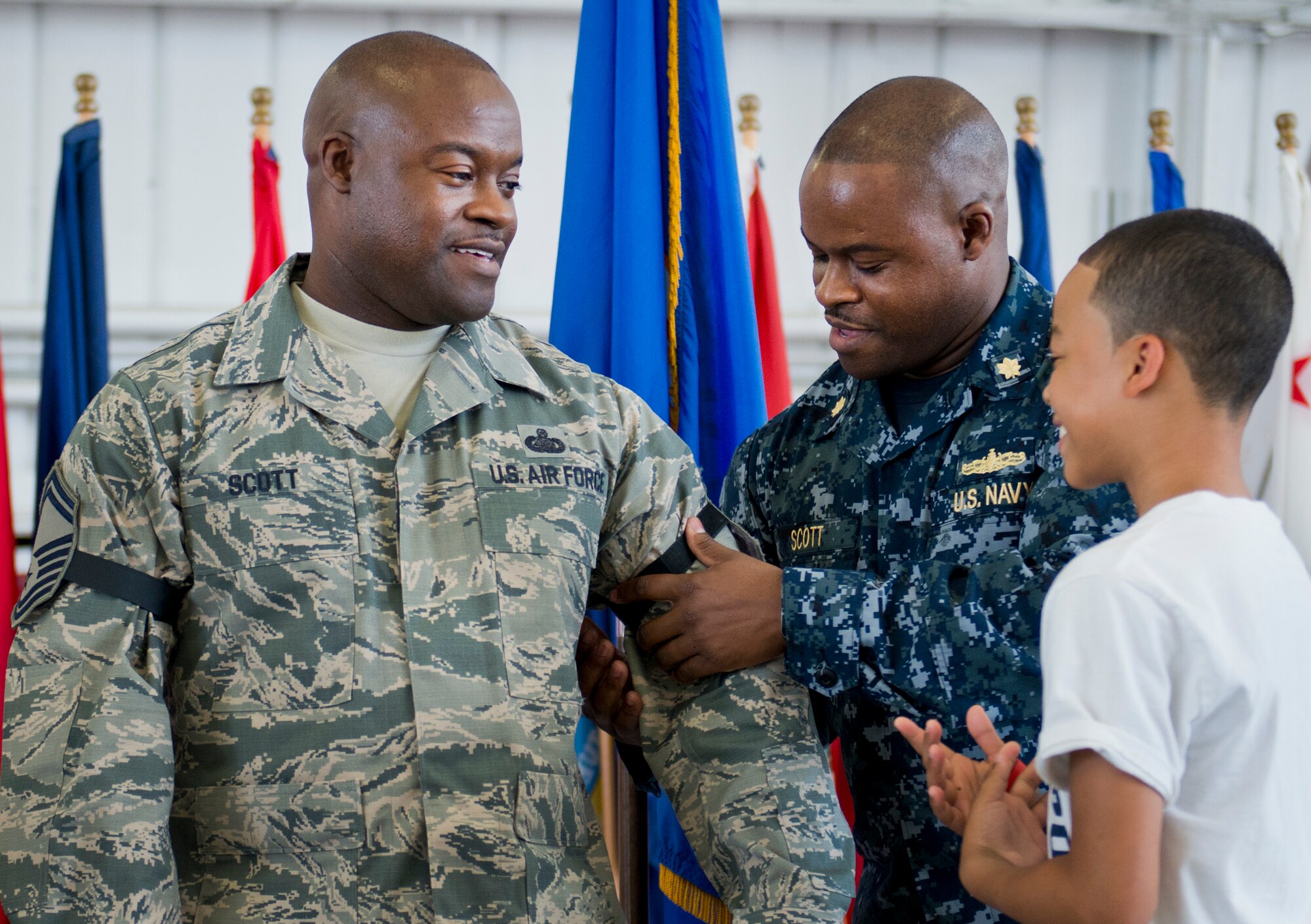 Master Sgt. Antone Scott, 96th Maintenance Group, has his new stripe put on by his son and his twin brother, Lt. Cmdr. Anthony Scott, during his promotion ceremony May 31 at Eglin Air Force Base, Fla.  Antone’s brother administered the oath of enlistment to the new senior master sergeant earlier in the day to meet the requirements for the promotion.  (U.S. Air Force photo/Samuel King Jr.)