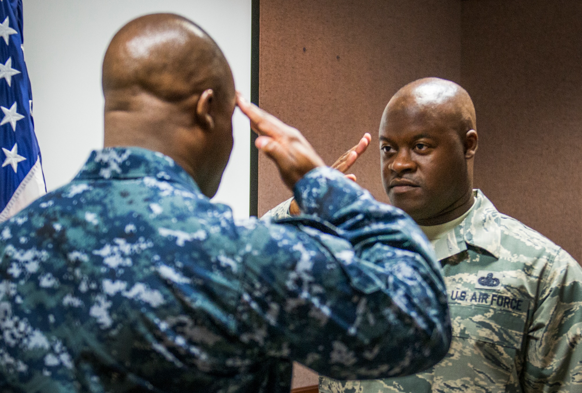 Master Sgt. Antone Scott, 96th Maintenance Group, salutes his twin brother, Lt. Cmdr. Anthony Scott, after reciting the oath of enlistment May 31 at Eglin Air Force Base, Fla.  This is the second time the twins participated in an enlistment ceremony together.  The first time was in 2013.  This enlistment allows Antone to put on his senior master sergeant stripe.  (U.S. Air Force photo/Samuel King Jr.)