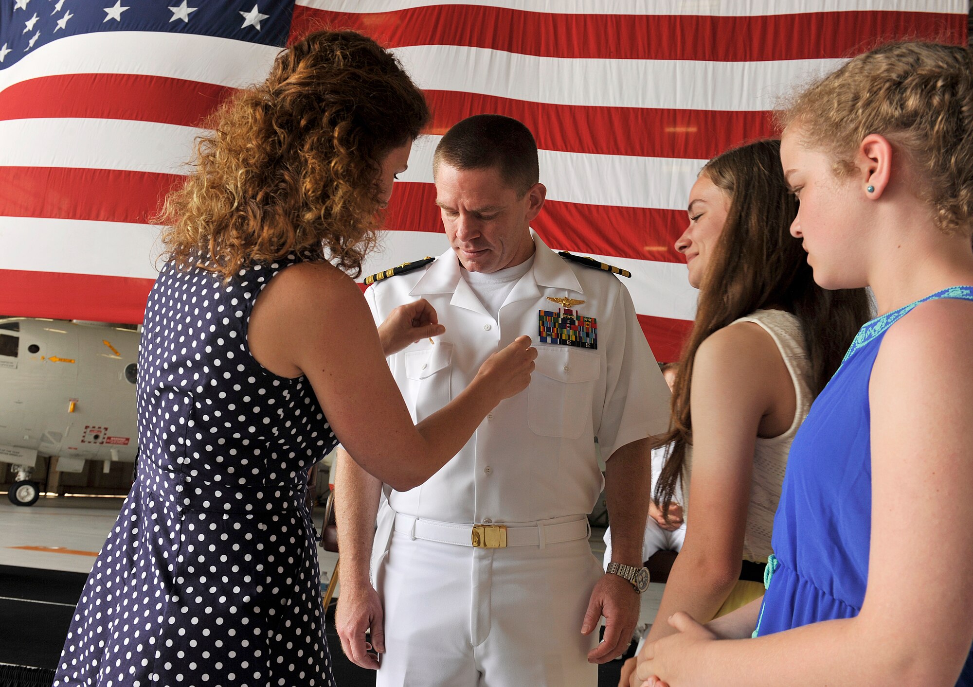 U.S. Navy Cmdr. Aaron Shoemaker, receives his command button from his family, during the Patrol Squadron Forty change of command ceremony, June 2, 2016, at Kadena Air Base, Japan. Shoemaker qualified as an instructor pilot and mission commander and deployed to, Puerto Rico; Manta, Ecuador; Keflavik, Iceland; and Sigonella, Italy. (U.S. Air Force photo by Naoto Anazawa)