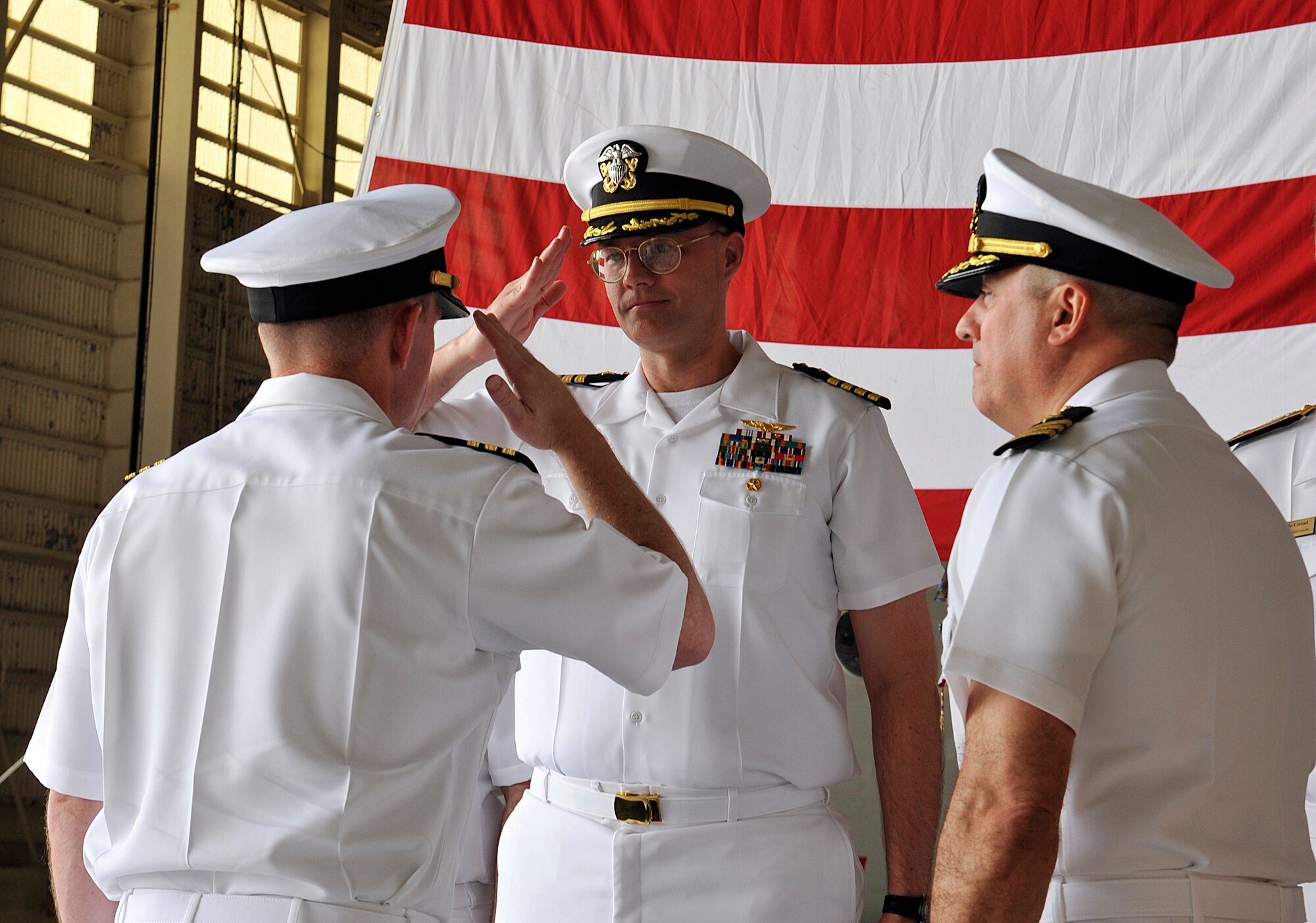 U.S. Navy Cmdr. Aaron Shoemaker, Patrol Squadron Forty commander (left), salutes Capt. Paul Peverly (center), Task Force 72 deputy commander, during the Patrol Squadron Forty change of command ceremony, June 2, 2016, at Kadena Air Base, Japan. The change of command ceremony represents the changing of authority between the outgoing and incoming commanders. (U.S. Air Force photo by Naoto Anazawa)