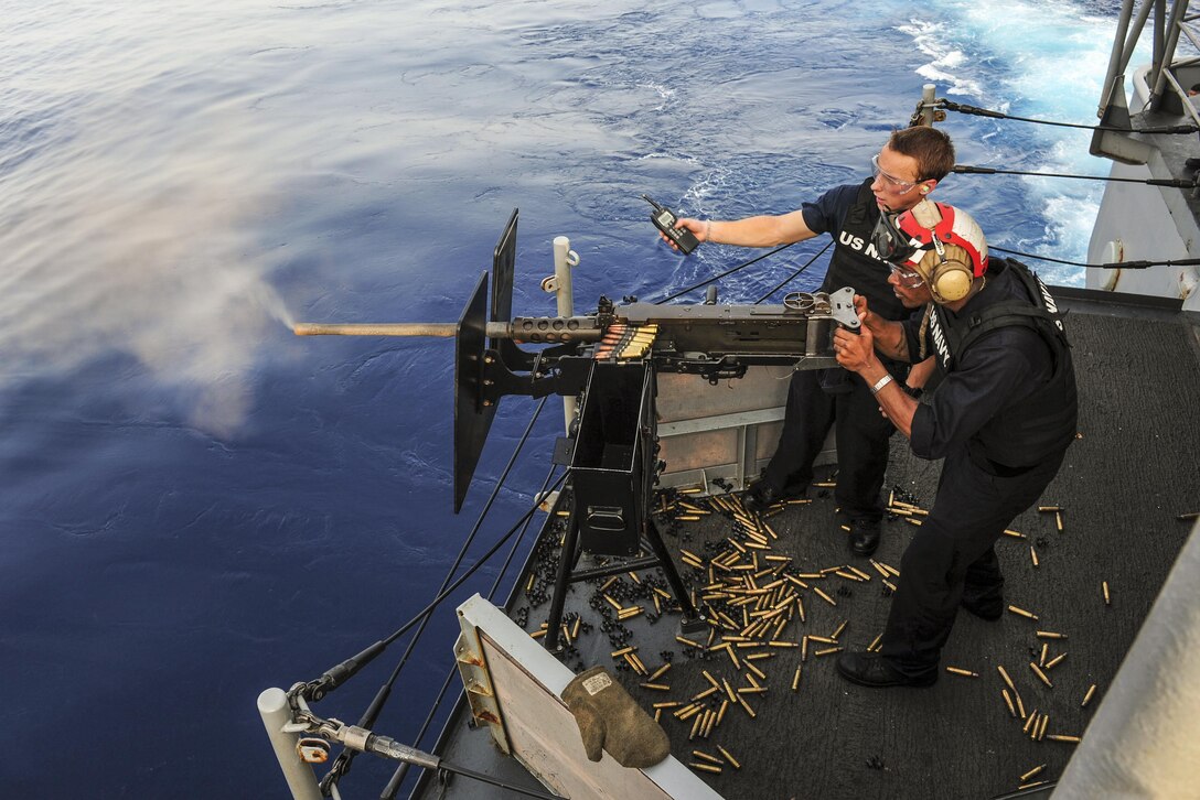 Navy Petty Officer 2nd Class Trey Dyer supervises Petty Officer 3rd Class Zakendrick Watson as he shoots a .50-caliber machine gun during a live-fire exercise aboard the USS Boxer in the Gulf of Aden, June 1, 2016. The amphibious assult ship is supporting efforts in the U.S. 5th Fleet area of operations. Dyer is a gunner's mate and Watson is an aviation ordnanceman. Navy photo by Seaman Eric Burgett