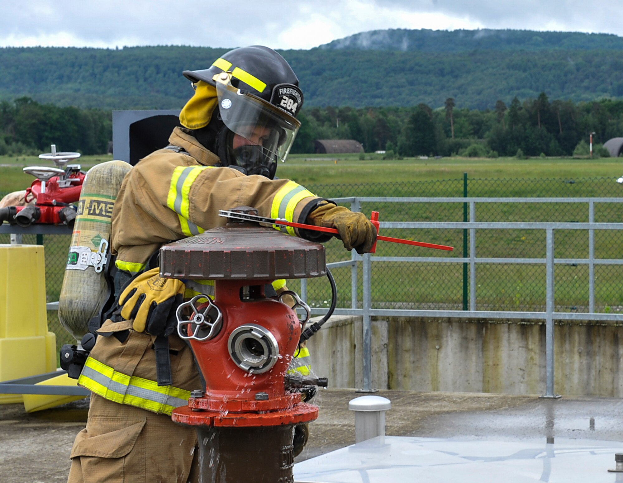 An 86th Civil Engineer Squadron Airman releases water through a fire hydrant during a biannual-training exercise June 2, 2016, at Ramstein Air Base, Germany. The Airmen participated in an exercise to test their skills for real-world emergencies. (U.S. Air Force photo/Senior Airman Larissa Greatwood)