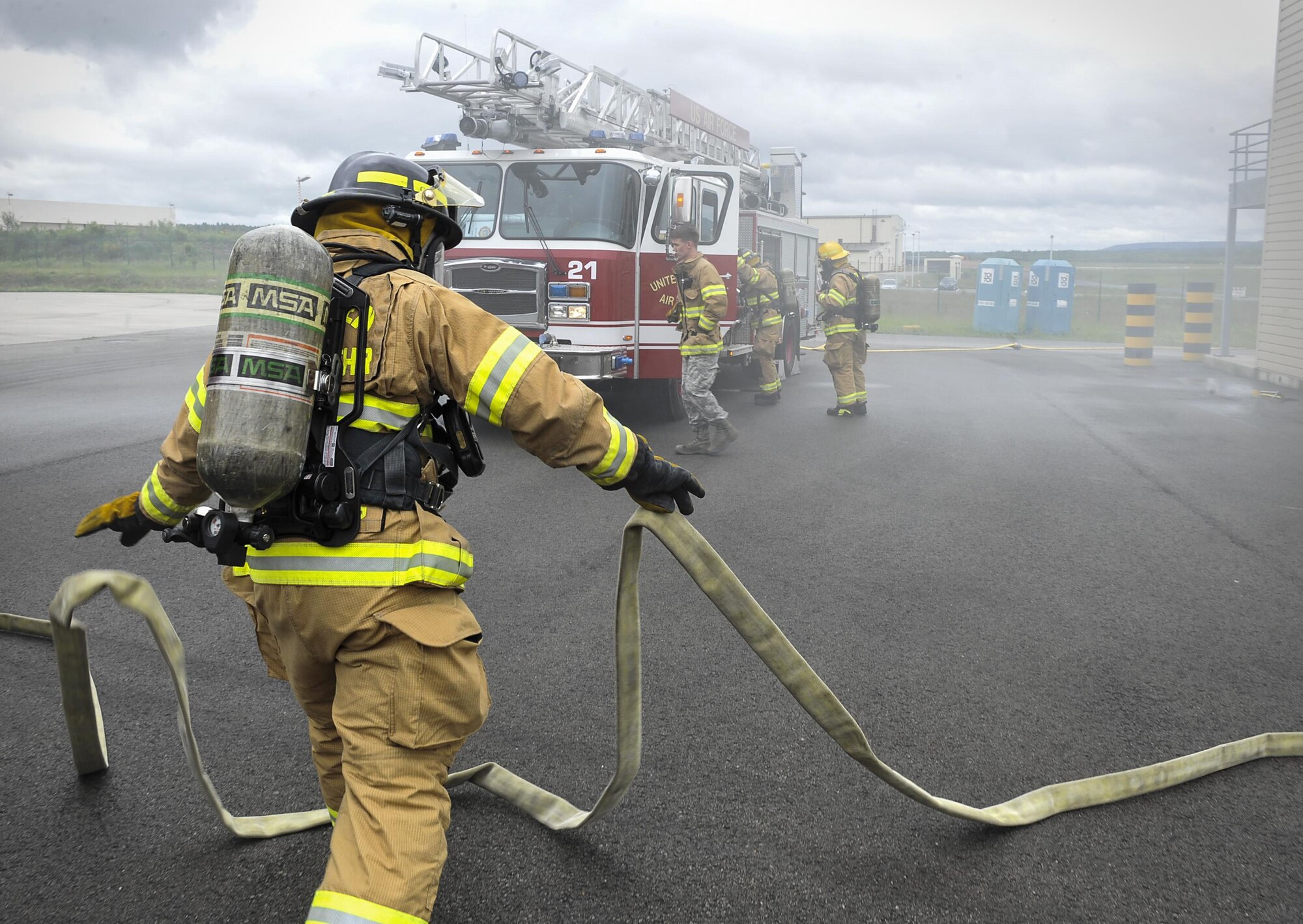 Airmen from the 86th Civil Engineer Squadron prepare fire hoses during a biannual-training exercise June 2, 2016, at Ramstein Air Base, Germany. Though Airmen are required to conduct each type of training annually, they continuously work to maintain and expand their skillsets. (Senior Airman Larissa Greatwood)