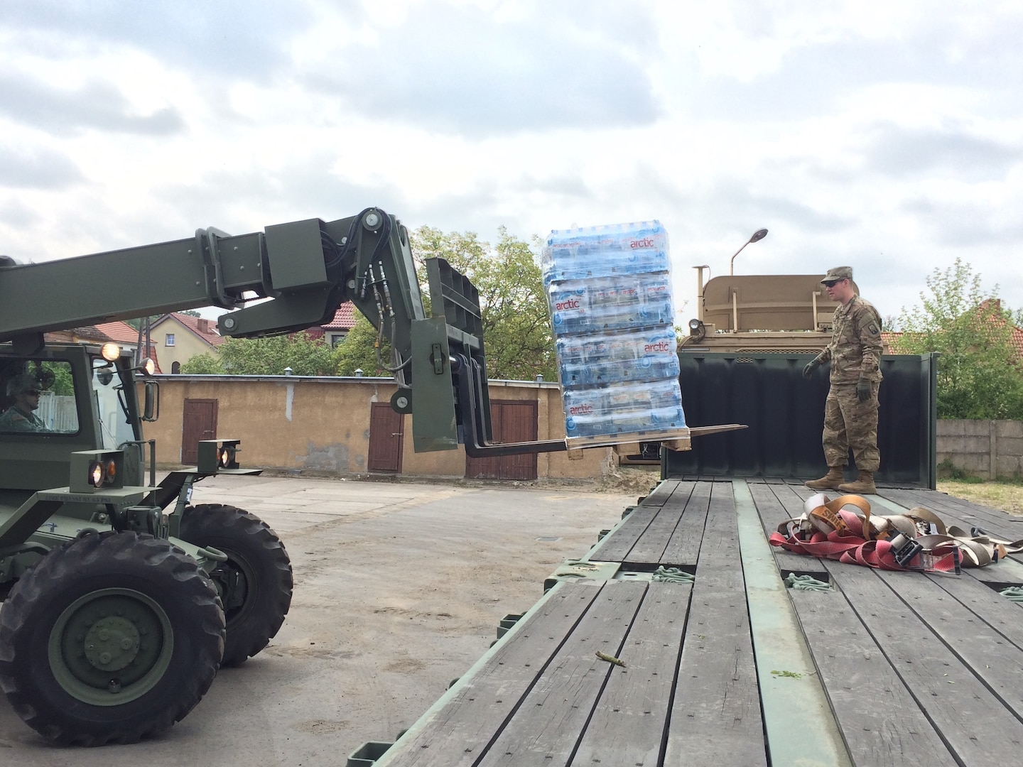 Spc. Daniel Ofier loads 10 pallets of water onto his trailer system for delivery to the logistic support area in Drawsko Pomorskie May 18.