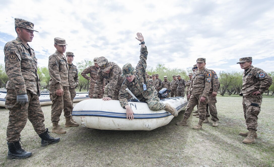 160530-N-WI365-037 ULAANBAATAR, Mongolia (May 30, 2016) – U.S. Marine Sgt. Nate Hitchcock, assigned to 3rd Reconnaissance Battalion, demonstrates proper hand gestures and signals to members of the Mongolian Armed Forces while aboard a combat rubberized raid craft (CRRC) during a small boat riverine training course. The small boat riverine training course is part of Khaan Quest 2016 and is the continuation of last week’s basic water survival course to familiarize MAF soldiers with different survival tactics in different environments that can be used during their deployment or U.N. missions. Khaan Quest 2016 is an annual, multinational peacekeeping operations exercise hosted by the Mongolian Armed Forces, co-sponsored by U.S. Pacific Command, and supported by U.S. Army Pacific and U.S. Marine Corps Forces, Pacific. Khaan Quest, in its 14th iteration, is the capstone exercise for this year’s Global Peace Operations Initiative program. The exercise focuses on training activities to enhance international interoperability, develop peacekeeping capabilities, build to mil-to-mil relationships, and enhance military readiness. (U.S. Navy photo by Mass Communication Specialist 3rd Class Markus Castaneda/RELEASED)