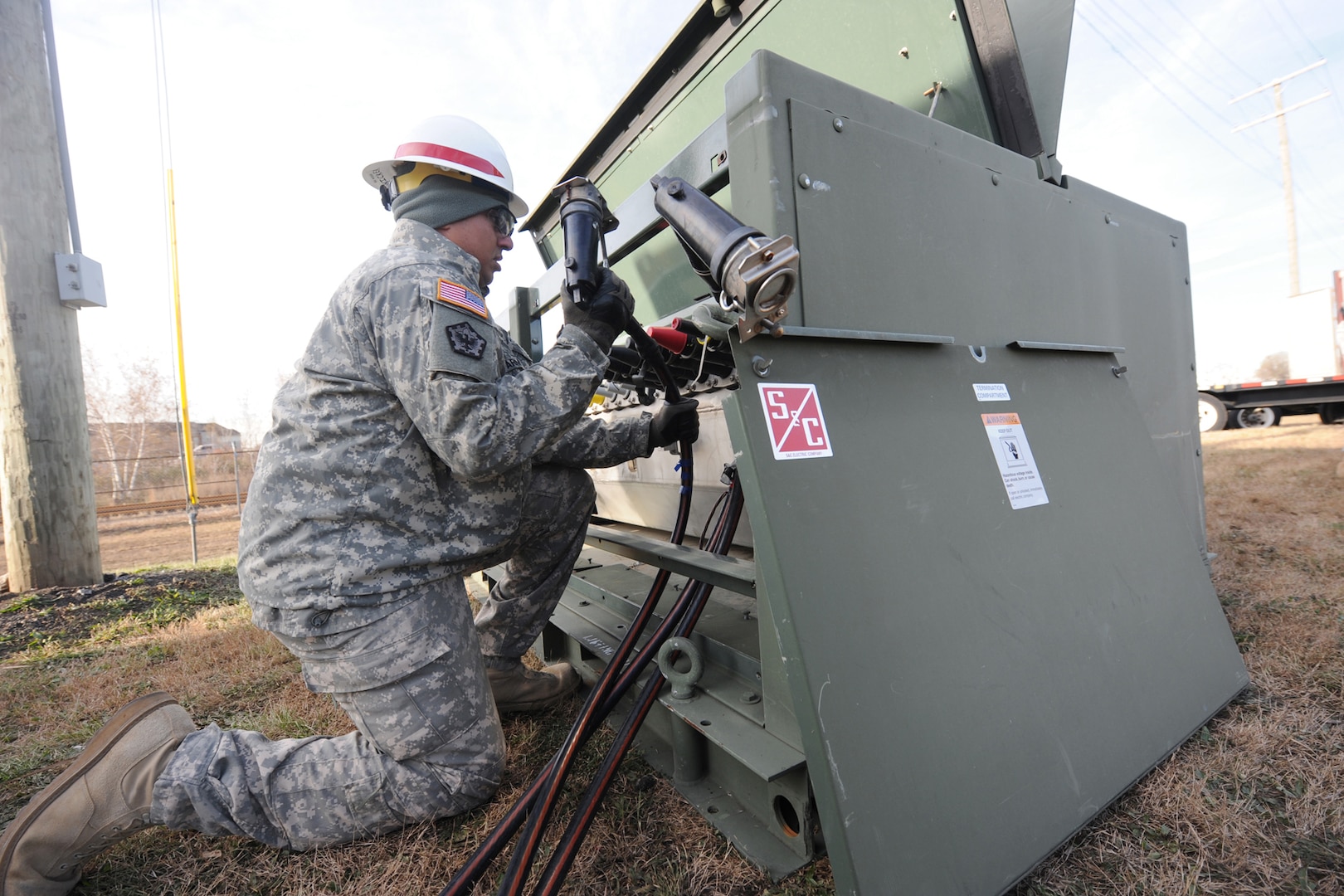 Spec. Arnold Wicker of the 249th Engineer Battalion (Prime Power) attaches cables to a power transfer box while installing generators at a Carteret, New Jersey power plant that lost power during Hurricane Sandy Nov. 6, 2012. DLA provided additional power generators to the Federal Emergency Management Agency to aid in the recovery effort.
