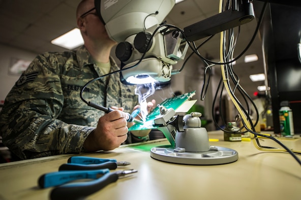 Staff Sgt. Kyle Eilefson, an Air Force Repair Enhancement Program technician with the 1st Special Operations Maintenance Squadron, solders resistors on a circuit board at Hurlburt Field, Fla., May 24, 2016. The circuit board is part of the power supply for the approach lighting system on the Hurlburt Field runway. (U.S. Air Force photo by Senior Airman Krystal M. Garrett)
