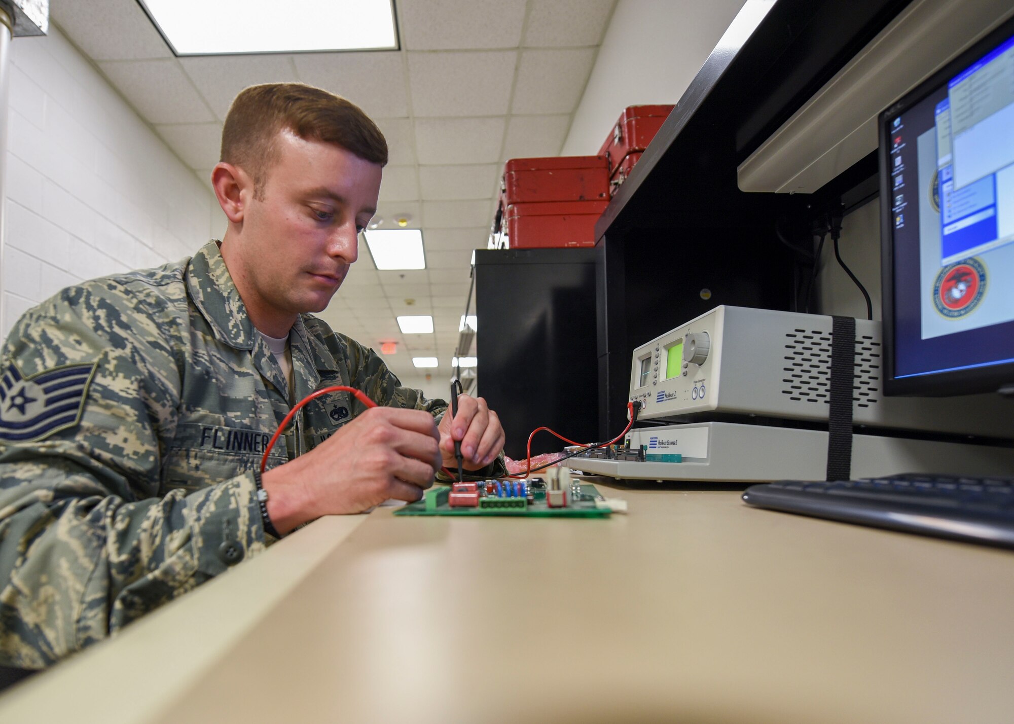 Tech. Sgt. Justin Flinner, an Air Force Repair Enhancement Program technician with the 1st Special Operations Maintenance Squadron, troubleshoots a circuit card utilizing a test station. The station allows for each individual component to be tested for defects. (U.S. Air Force photo by Senior Airman Krystal M. Garrett) 
