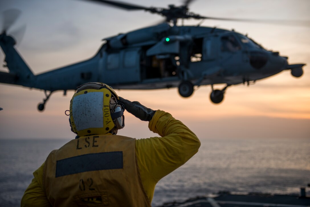 Navy Petty Officer 3rd Class Bryan Duncan, a boatswain's mate, salutes an MH-60S Sea Hawk helicopter on the flight deck of the guided missile destroyer USS Gonzalez, May 11, 2016, in the Gulf of Aden. The Gonzalez, along with the rest of the Harry S. Truman Carrier Strike Group, transited the Suez Canal yesterday to join operations against the Islamic State of Iraq and the Levant. Navy photo by Petty Officer 3rd Class Pasquale Sena
