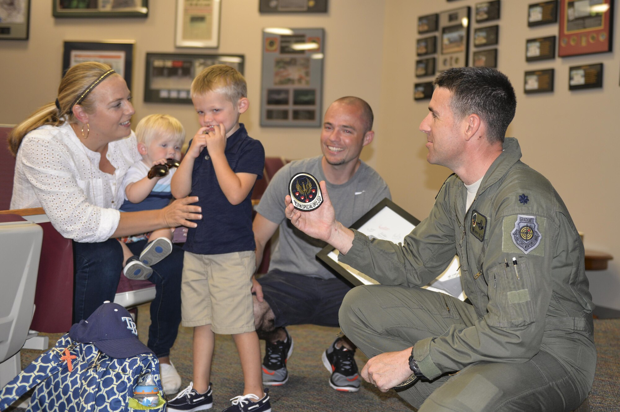 Lt. Col. Jason Allen, right, commander of the 15th Special Operations Squadron, offers four-year-old Carson Lester, middle, the 15th SOS patch at Hurlburt Field, Fla., May 26, 2016. Lester is the star of a photograph taken during a family-photo session that was ‘photobombed’ by an MC-130H Combat Talon II and was invited to the 15th SOS to get an up-close look at a Talon II.
