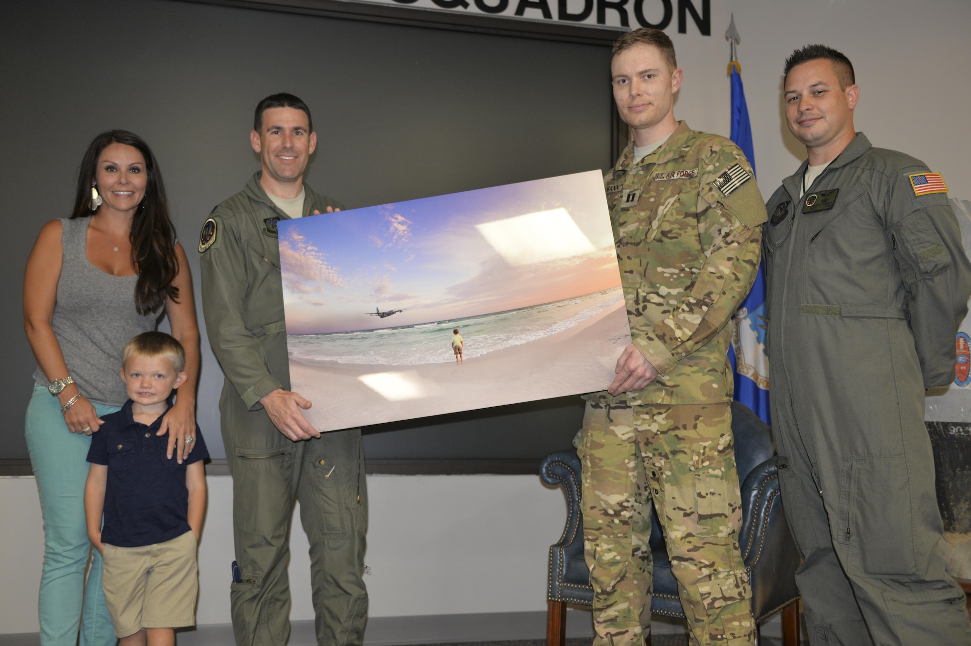 Local photographer, Kansas Pitts, left, presents the 15th Special Operations Squadron with a copy of the photograph that went viral on social media of four-year-old Carson Lester being ‘photobombed’ by an MC-130H Combat Talon II from the 15th SOS at Hurlburt Field, Fla., May 26, 2016. Pitts took the photo during a family-photo session on Stallworth Preserve, Santa Rosa Beach, Fla.