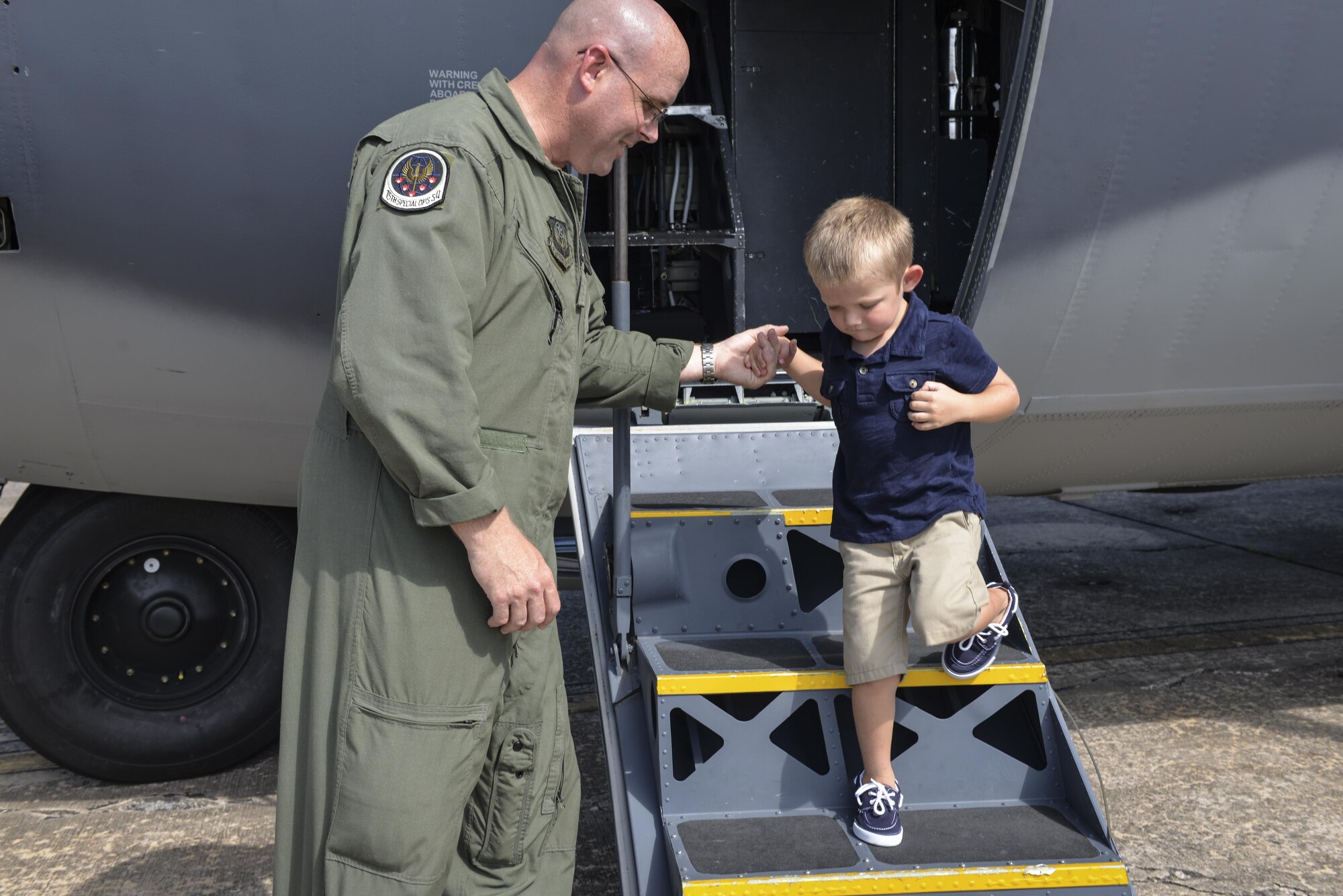 Master Sgt. William Kowalski II, left, a loadmaster crew position chief with the 15th Special Operations Squadron, helps four-year-old Carson Lester down the stairs as he exits an MC-130H Combat Talon II at Hurlburt Field, Fla., May 26, 2016. Lester is the star of a photograph taken during a family-photo session that was ‘photobombed’ by a Talon II and was invited to the 15th SOS to get an up-close look at the aircraft.
