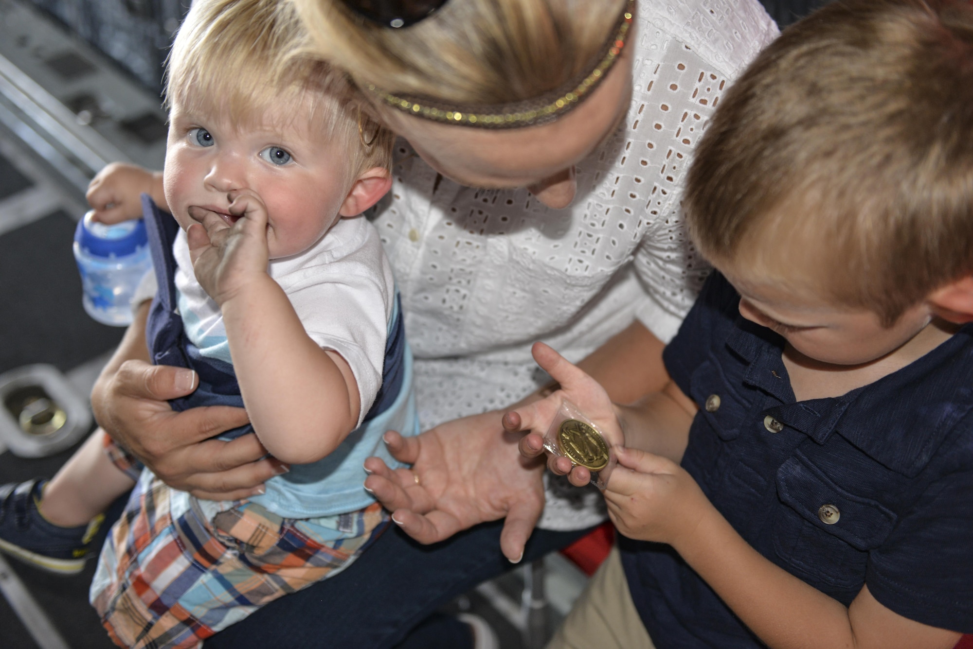 Four-year-old Carson Lester, right, shows his Mom, Jessica Lester, the coin he received from Lt. Col. Jason Allen, commander of the 15th Special Operations Squadron, during his visit at Hurlburt Field, Fla., May 26, 2016. Lester is the star of a photograph taken during a family-photo session that was ‘photobombed’ by an MC-130H Combat Talon II and was invited to the 15th SOS to get an up-close look at the aircraft.