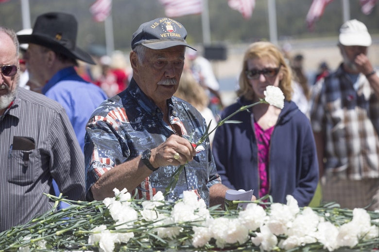 A ceremony attendee lays a carnation atop a casket to pay respect to fallen service members during the Memorial Day Ceremony in Veteran’s Park at Big Bear Lake, Calif., May 30, 2016. Sgt. Maj. Michael J. Hendges, Combat Center Sergeant Major, represented the Combat Center as the guest speaker in the Memorial Day Ceremony spoke about the importance of remembering the ultimate sacrifice many American service members have paid. (Official Marine Corps photo by Cpl. Medina Ayala-Lo/Released)