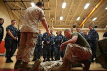 Petty Officer 3rd Class Ivan Jordan explains the importance of tourniquet placement to U.S. Naval Sea Cadet Corps cadets, April 29, during a Marine open house at the Hopkins Hall Gym, at Camp Allen, Virginia. The Marine open house allowed the cadets to get a glimpse at how a Marine or sailor would train with Fleet Anti-Terrorism Security Team. During the tour, the cadets viewed different stations ranging from weapon familiarization to combat life saver displays. Anderson is a Houston native and a team leader with Alpha 2, FAST Company, Marine Security Forces Regiment. (U.S. Marine Corps photo by Cpl. Jessika Braden/Released)