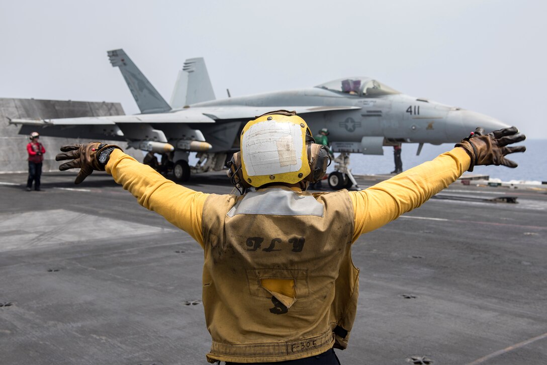 Navy Petty Officer 3rd Class Raimon Hubbard directs an F/A-18E Super Hornet on the flight deck of the aircraft carrier USS Harry S. Truman in the Mediterranean Sea, June 3, 2016. The USS Truman and its Carrier Strike Group are supporting Operation Inherent Resolve, maritime security operations and theater security cooperation efforts in the U.S. 6th Fleet area of operations. The Hornet is assigned to Strike Fighter Squadron 25. Navy photo by Petty Officer 3rd Class Anthony Flynn