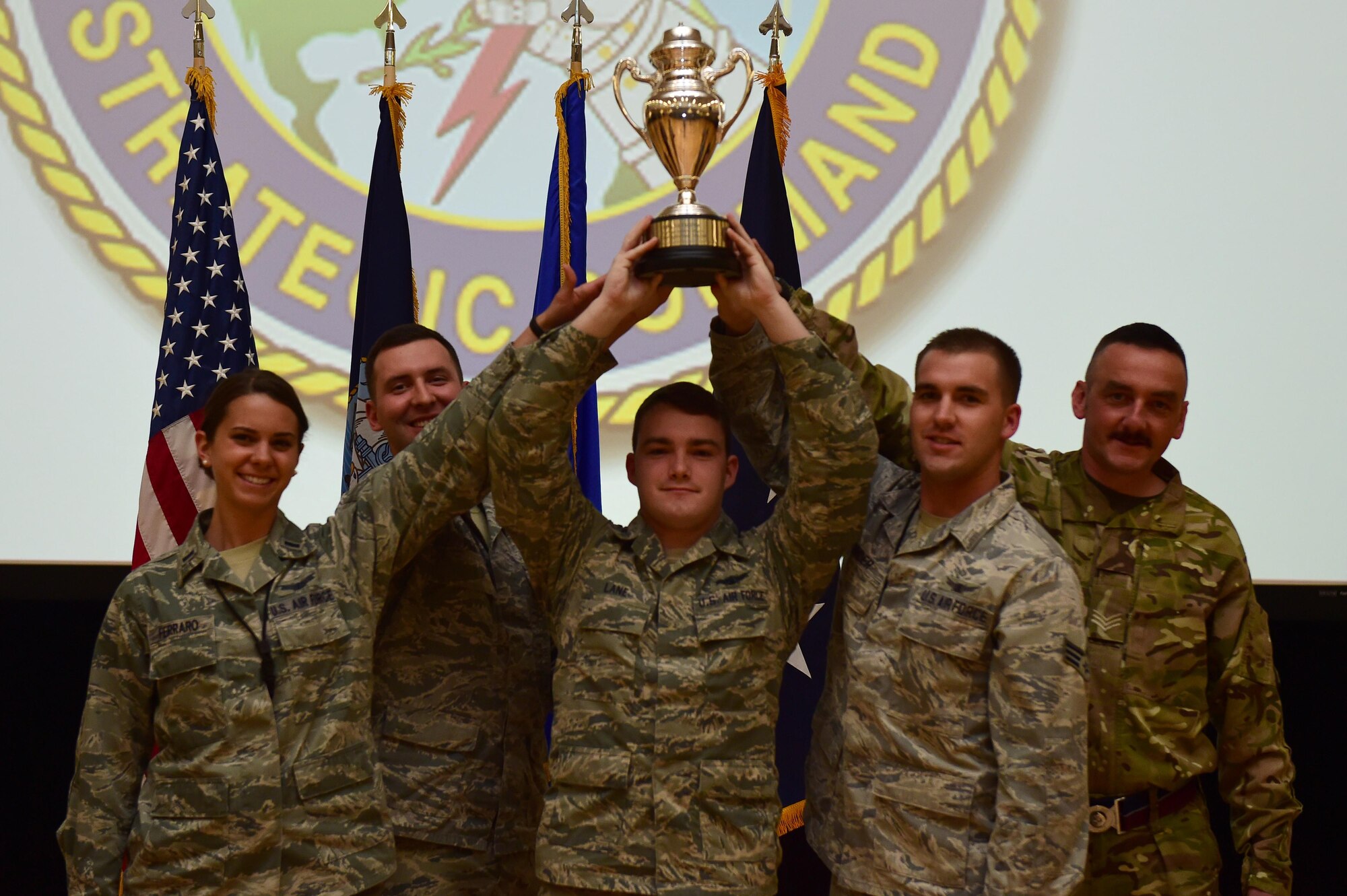 Members of the 460th Space Wing hold up the Omaha Trophy during a commander’s call April 15, 2016, on Buckley Air Force Base, Colo. The wing won the trophy for the first time by executing more than 8,000 error-free operation hours and providing critical missile warning and missile defense. (U.S. Air Force photo by Airman 1st Class Gabrielle Spradling/Released)