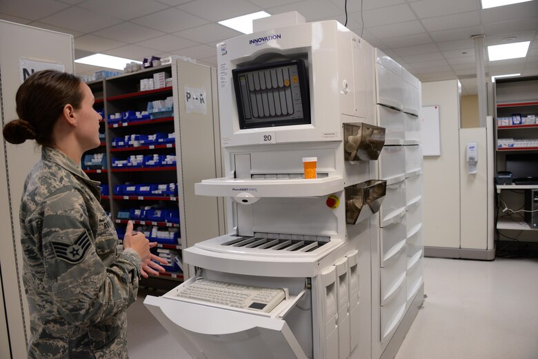 Staff Sgt. Karli Root, 60th Diagnostics and Therapeutics Squadron phase II pharmacy instructor, demonstrates the capabilities of the PharmAssist Robot in the outpatient pharmacy at Travis Air Force Base, Calif., May 24, 2016. The robots fill approximately 50 to 60 percent of the prescriptions in the outpatient pharmacy. The robots and personnel in the outpatient pharmacy fill between 700 to 1,000 prescriptions a day. (U.S. Air Force photo by Senior Airman Amber Carter)