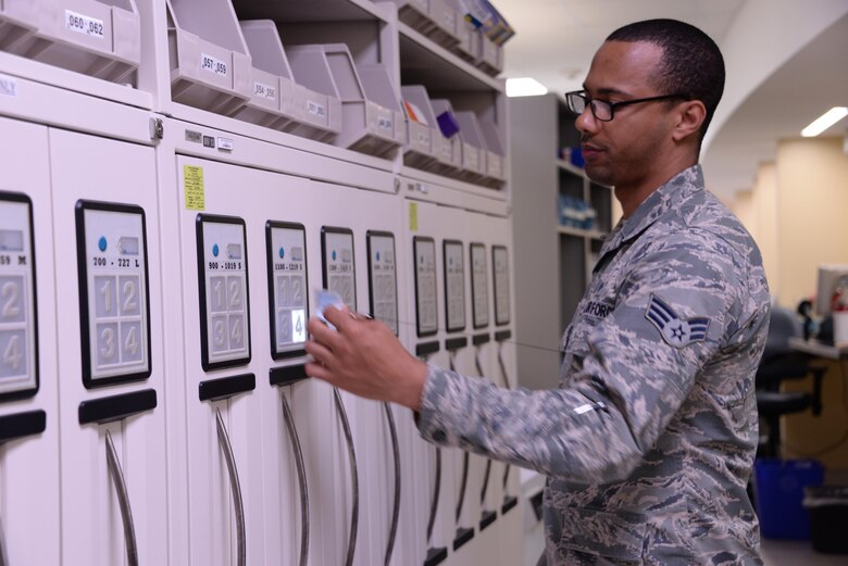 Senior Airman Patrick Taylor, 60th Diagnostics and Therapeutics Squadron pharmacy technician, uses his badge to collect filled prescriptions from a GSL at David Grant USAF Medical Center at Travis Air Force Base, Calif., May 24, 2016.. DGMC is a main hub for Phase II training of pharmacy technicians, graduating 70 Airmen a year. (U.S. Air Force photo by Senior Airman Amber Carter)