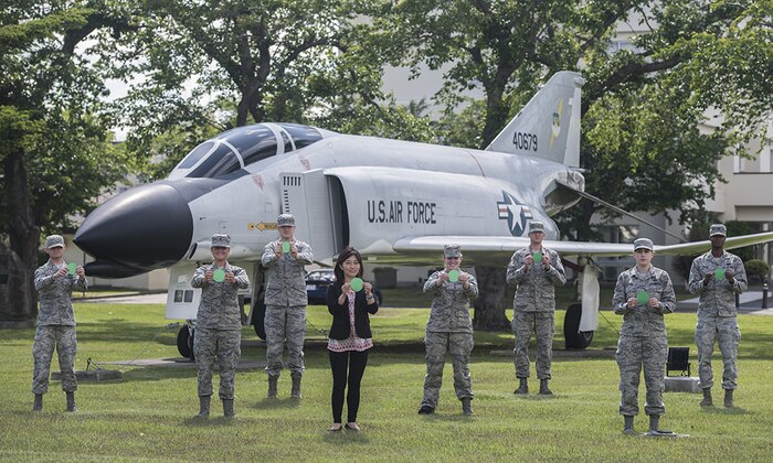 Personnel from the 35th Fighter Wing Public Affairs office hold green dots at Misawa Air Base, Japan, June 02, 2016. The non-profit organization Green Dot has been awarded a contract by the U.S. Air Force to support its five-year strategy to curb interpersonal violence across the service. Under the terms of the agreement, Green Dot will provide the USAF with violence prevention tools for a period of three years. 