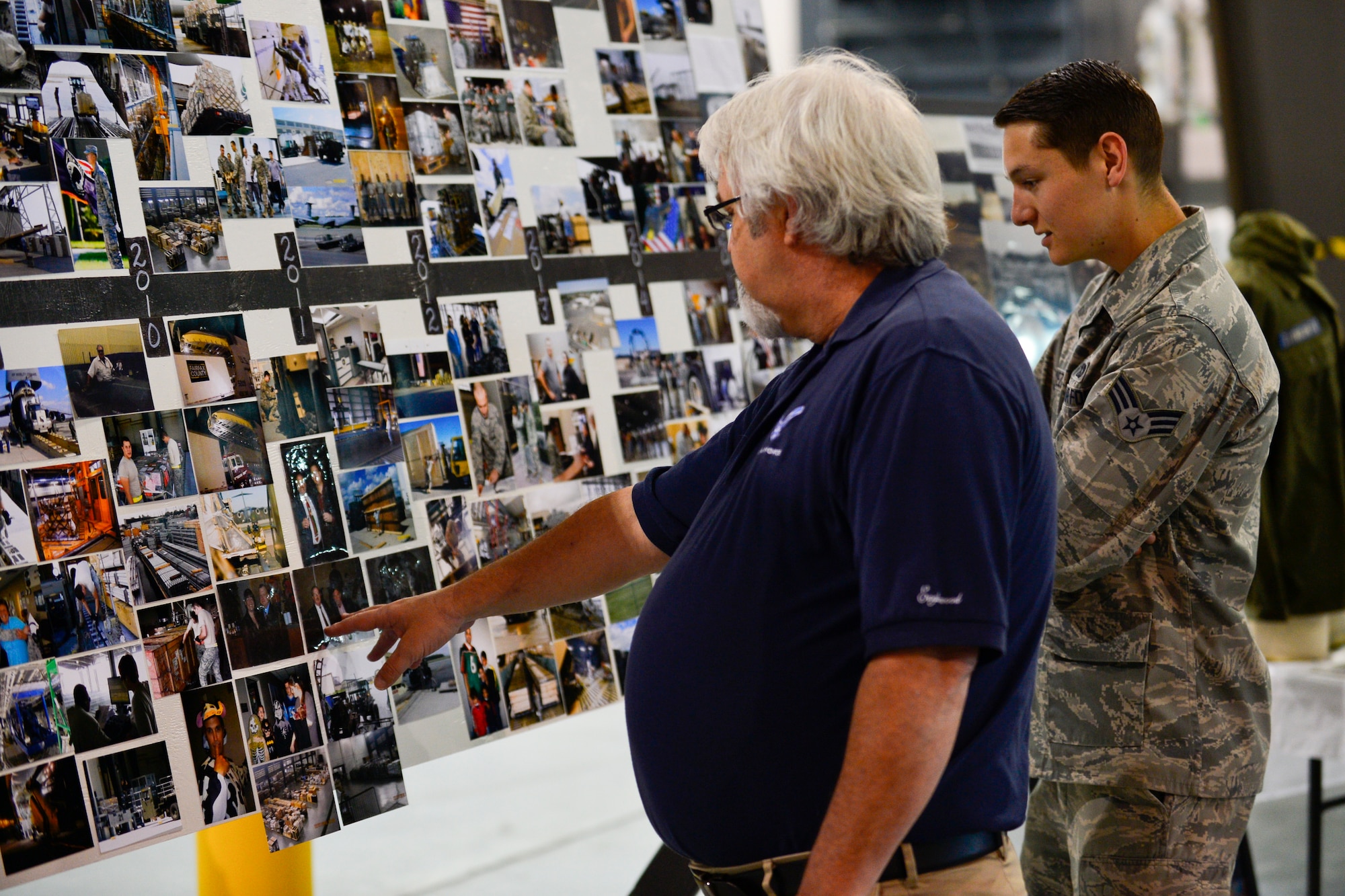 Retired Master Sgt. Ronnie Allen looks at photos from 2011 that were on display during the 436th Aerial Port Squadron 50th Anniversary Celebration May 20, 2016, inside of the aerial port on Dover Air Force Base, Del. The wall of photos featured a timeline of the Super Port’s history dating back to the 1960s. (U.S. Air Force photo/Senior Airman William Johnson)