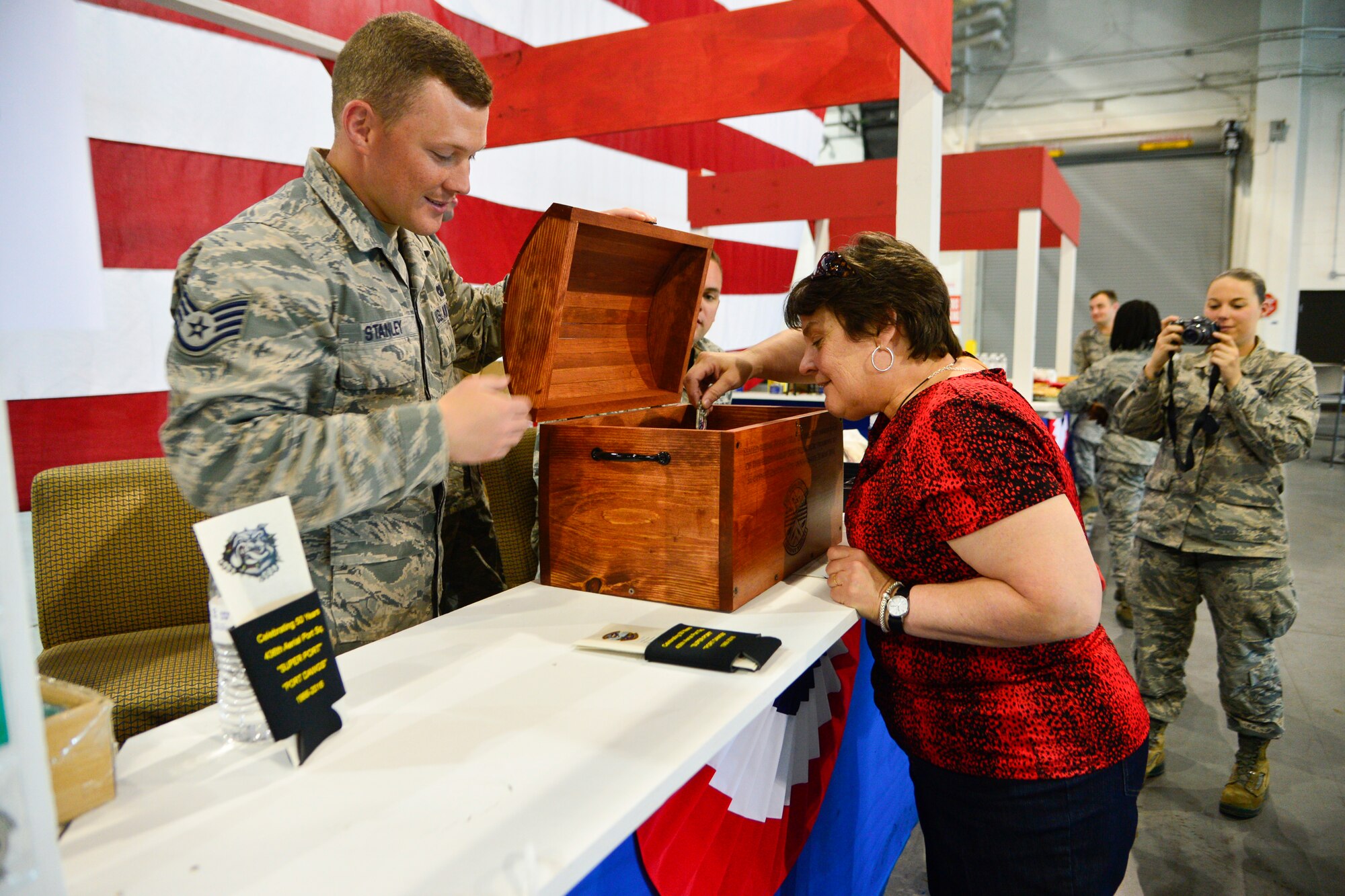 Jean Gross places a coin inside of a time capsule during the 436th Aerial Port Squadron 50th Anniversary Celebration May 20, 2016, inside of the aerial port on Dover Air Force Base, Del. The time capsule will be sealed for 25 years and re-opened on the aerial port’s 75th anniversary on May 20, 2041. (U.S. Air Force photo/Senior Airman William Johnson)
