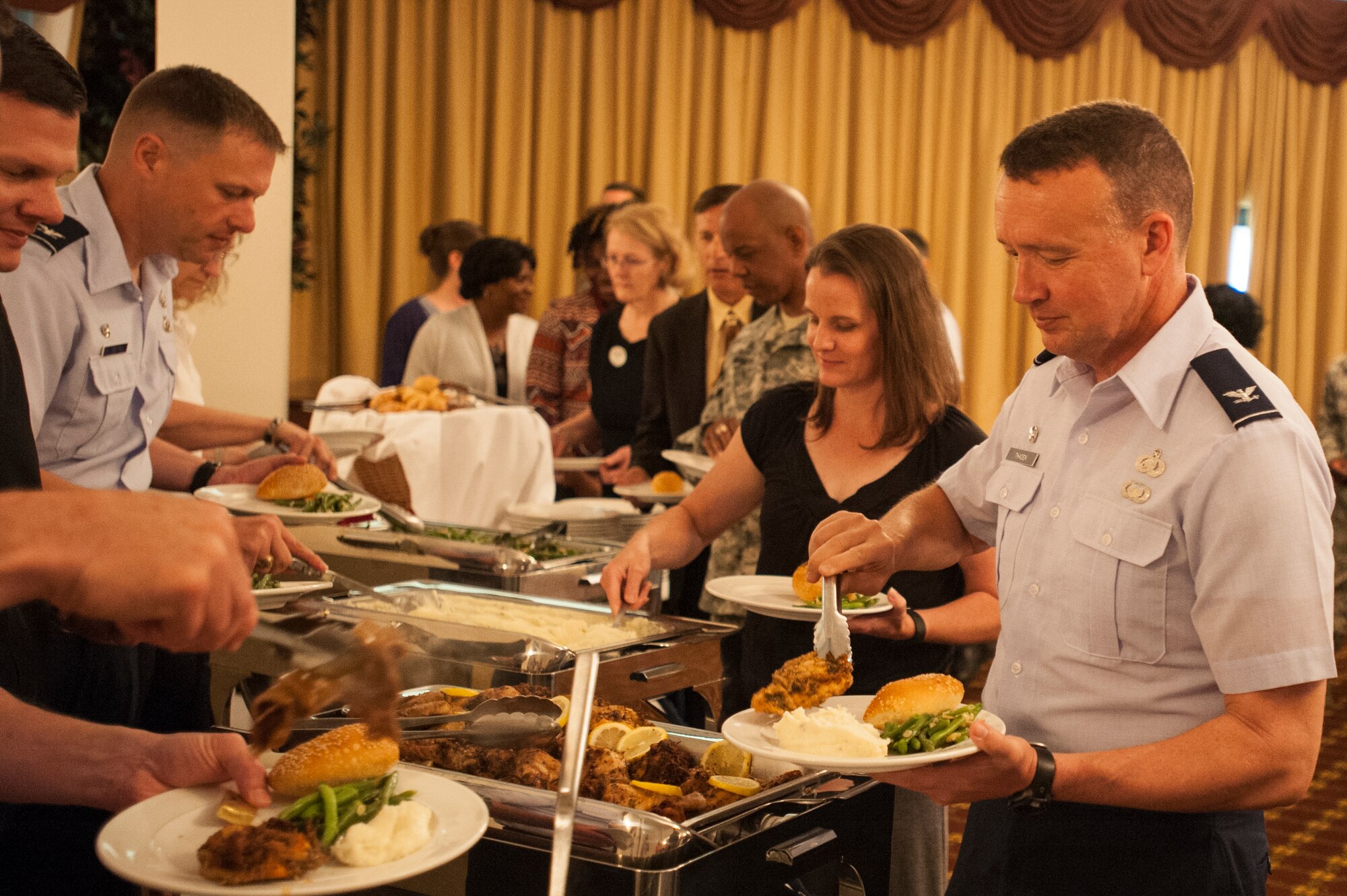 Col. Frederick Thaden, Joint Base McGuire-Dix-Lakehurst and 87th Air Base Wing commander, and others guests get something to eat at the Spouse Appreciation Luncheon at Tommy B’s Community Center at Joint Base McGuire-Dix-Lakehurst, June 1, 2016. The luncheon provided food and entertainment as a thank you to military spouses. (U.S. Air Force photo by Airman 1st Class Zachary Martyn/released)