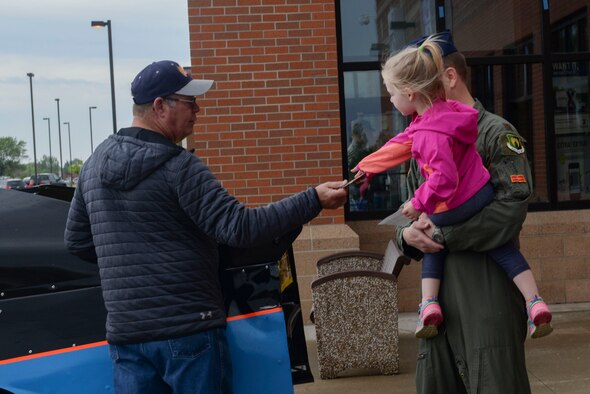 Maj. Jake Whitlock, deputy chief from the 5th Operations Group, and his daughter visit with drivers from the NoDak Speedway at Minot Air Force Base, N.D., May 25, 2016. Drivers were displaying cars, did some giveaways and informed Team Minot of the speedway events this summer and on May 30 for Military Appreciation Day. (U.S. Air Force photo/Airman 1st Class Jessica Weissman)