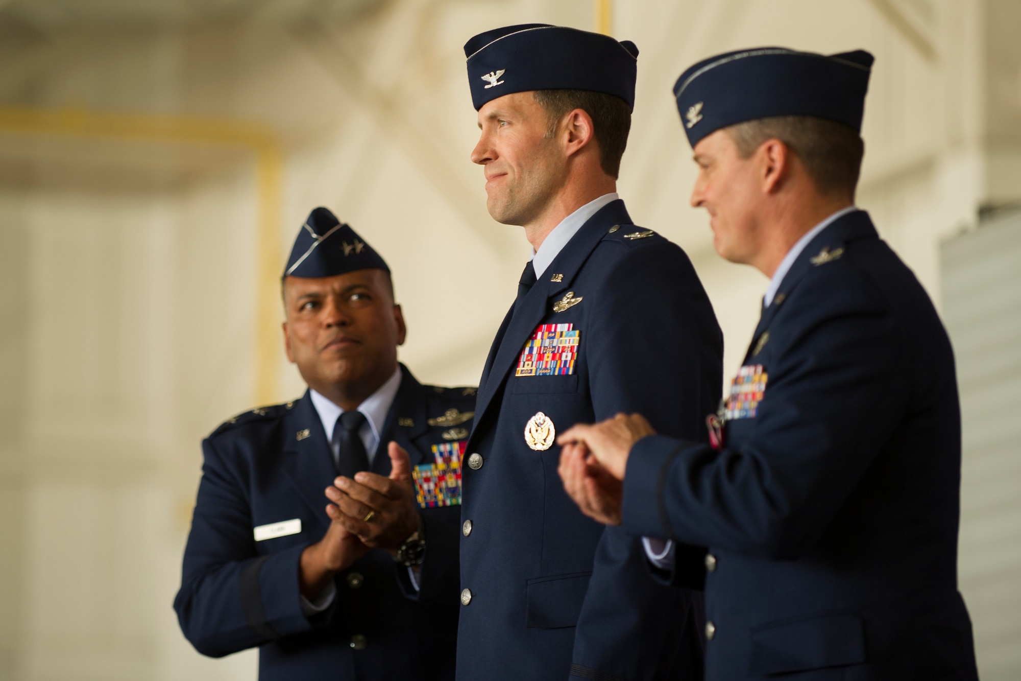Maj. Gen. Richard Clark, Eighth Air Force commander, and Col. Jason Armagost applaud Col. Michael Brooks as he is officially named commander of the 5th Bomb Wing during the 5th BW change of command ceremony at Minot Air Force Base, N.D., June 3, 2016. Brooks is the 5th BW’s 54th commander. (U.S. Air Force photo/Senior Airman Apryl Hall)