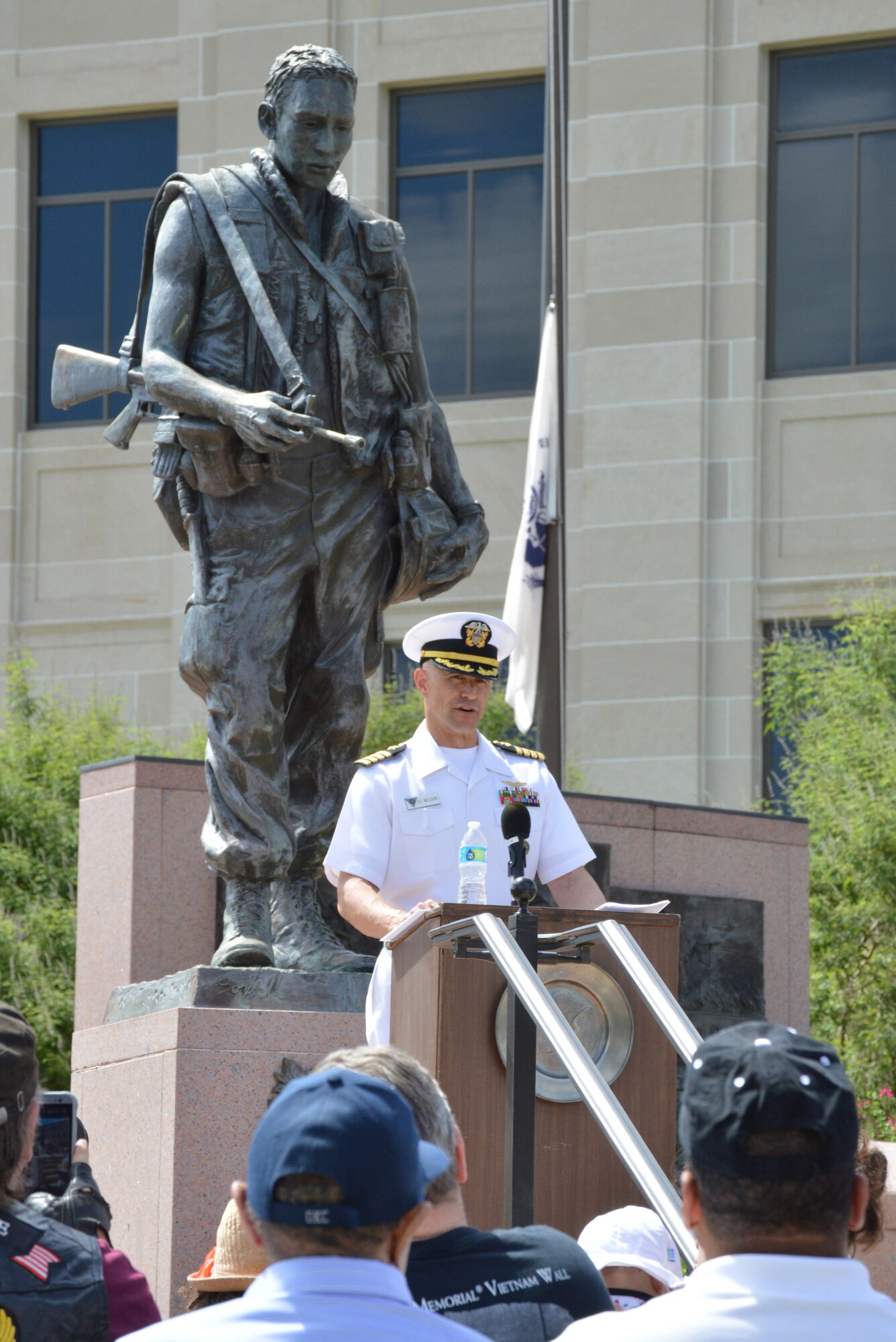 Navy Capt. Ed McCabe, deputy commander of Strategic Communications Wing ONE and Task Force 124, speaks to a crowd of veterans during a Memorial Day program May 30 at Veterans Memorial Park at the state capitol. “On a day when we officially honor the memory of those who have gone before us, those veterans who made the ultimate sacrifice, we look to the words of President John F. Kennedy, ‘A nation reveals itself not only by the men it produces but also by the men it honors, the men it remembers,’” he said. “As Americans, may we forever commit to revealing our nation as one that holds true the memory and full measure of sacrifice our nation’s heroic men and women have given for freedom for us all.” Tinker Chaplain (Capt.) Bill Mesaeh Jr. also participated in the program.  (Air Force photo by April McDonald/Released)