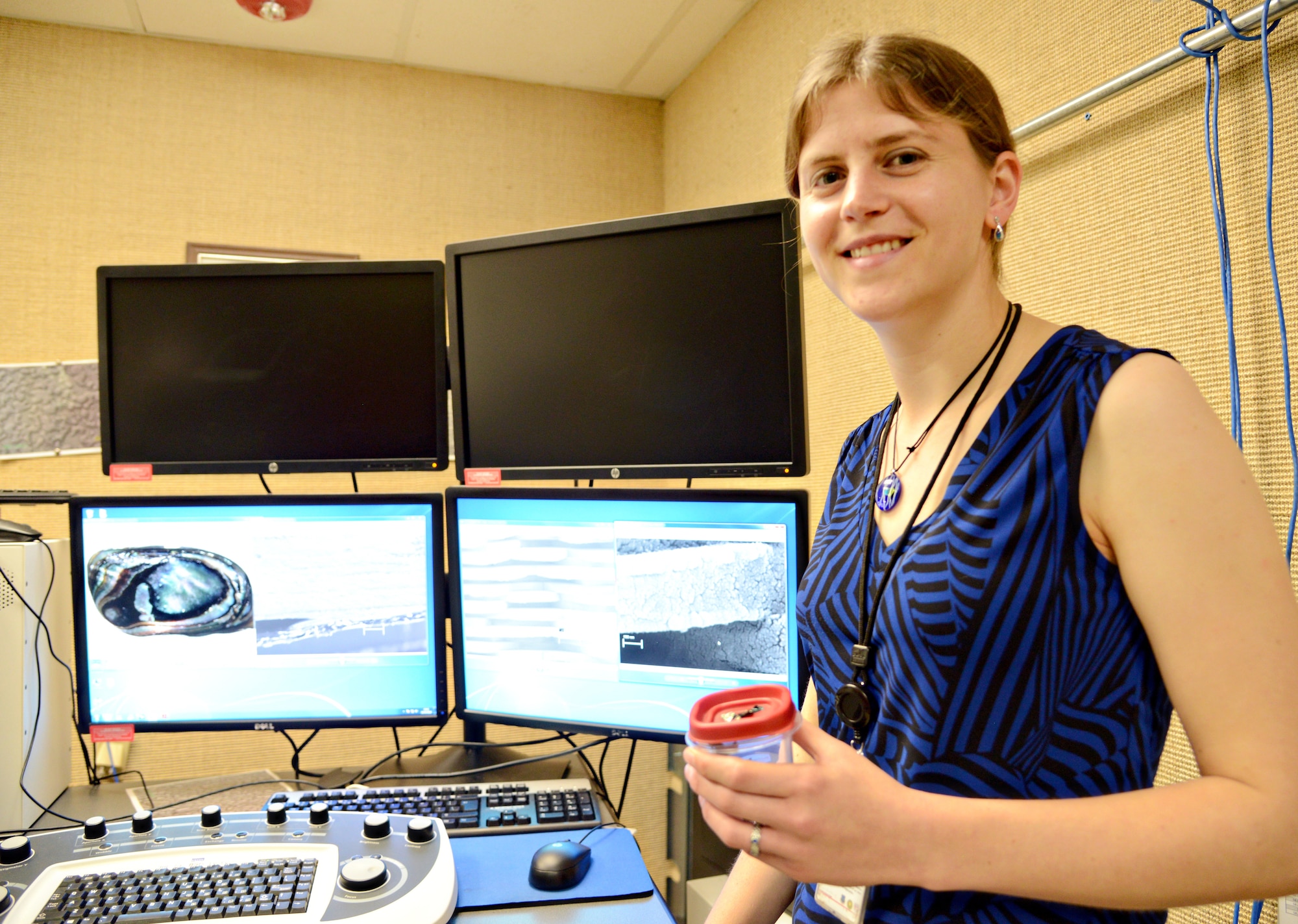 Emily Heyne, a materials engineer, demonstrates the magnification power of the field emission scan electron microscope (FESEM) with a piece of sea shell. The FESEM is capable of magnifying up to one-million times. (Air Force photo by Kelly White/Released)