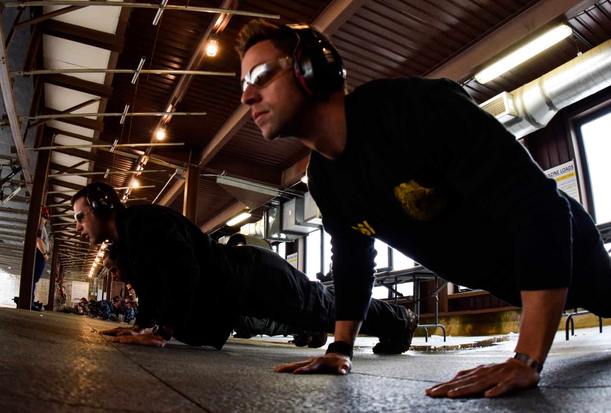 Office of Special Investigations Special Agent Jesse Galvan, foreground, leads a line-up of participants in doing push-ups during the 72nd Security Forces Squadron pistol competition in conjunction with Police Week 2016 actvities on Tuesday May 17, 2016, Tinker Air Force Base, Okla. Each competitor did 14 push-ups in memory of the 14 law enforcement officers lost in the line-of-duty in the last year to provide a physical challenge to the shooting competition. (U.S. Air Force photo/Greg L. Davis)