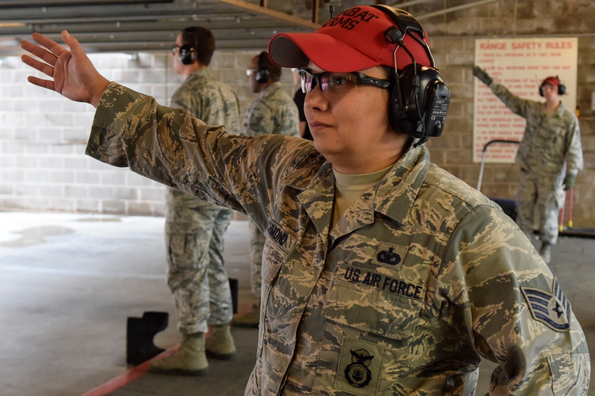 Staff Sgt. Joanna Richmond, 72nd Security Forces Squadron combat arms instructor, motions wit her right hand her section of the firing range is clear and safe for shooting while Staff Sgt. Staff Sgt. Greg Peterson, 72nd SFS combat arms instructor, gives the same signal during a pistol competition hosted by the 72 SFS in conjunction with Police Week 2016 activities on Tuesday May 17, 2016, Tinker Air Force Base, Okla. Combat arms instructors wear red hats for easy identification in loud, potentionally hazardous environments such as the live-fire range shown here. (U.S. Air Force photo/Greg L. Davis)