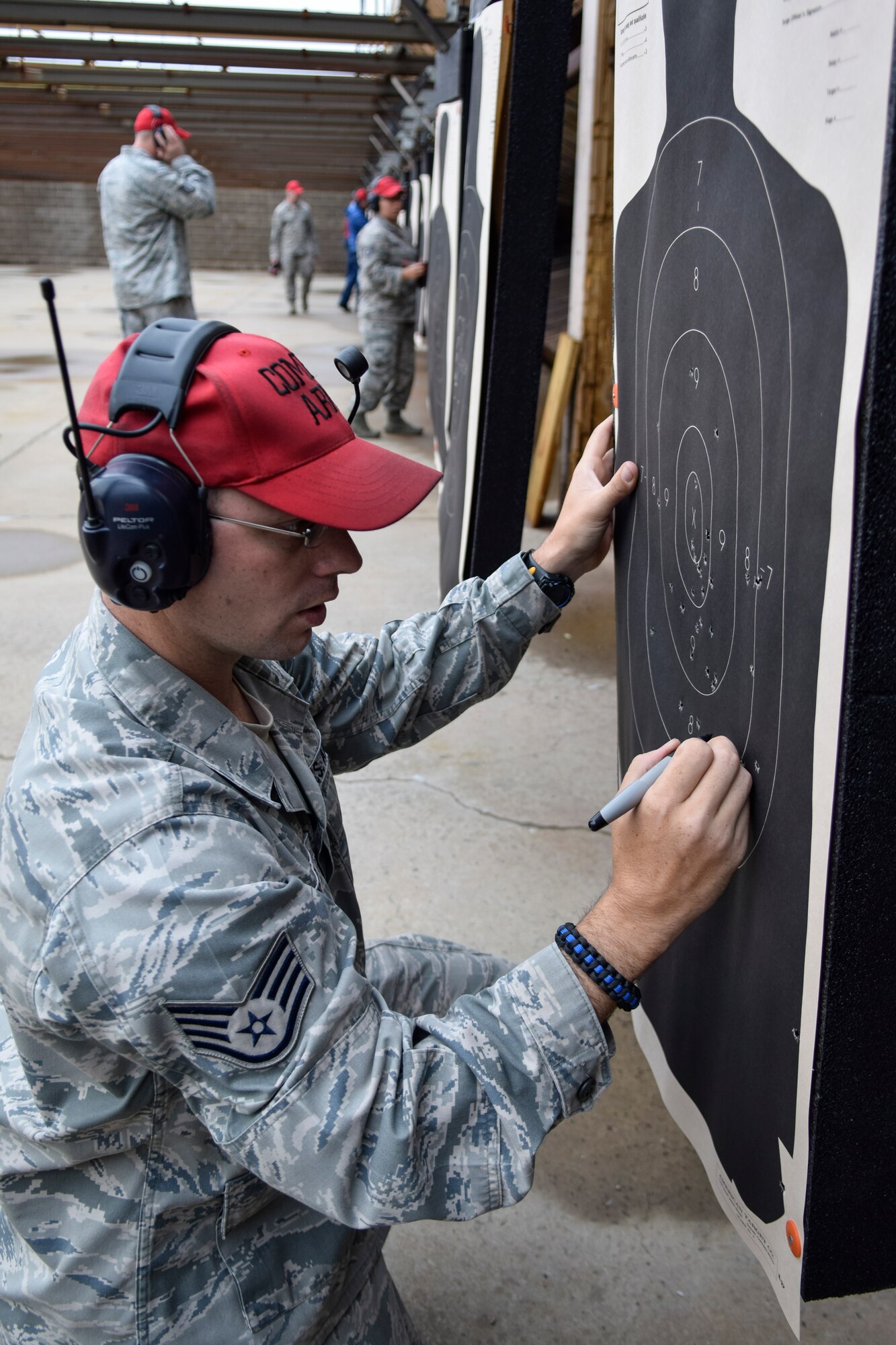 Staff Sgt. Greg Peterson, 72nd Security Forces Squadron combat arms instructor, tallies the score from hits on a silhouette target during a break in shooting at a pistol competition hosted by the 72 SFS in conjunction with Police Week 2016 activities on Tuesday May 17, 2016, Tinker Air Force Base, Okla. Peterson and other combatr arms instructors acted as safety observers and scorekeepers during the event which challenged shooters during both speed and accuracy events. (U.S. Air Force photo/Greg L. Davis)