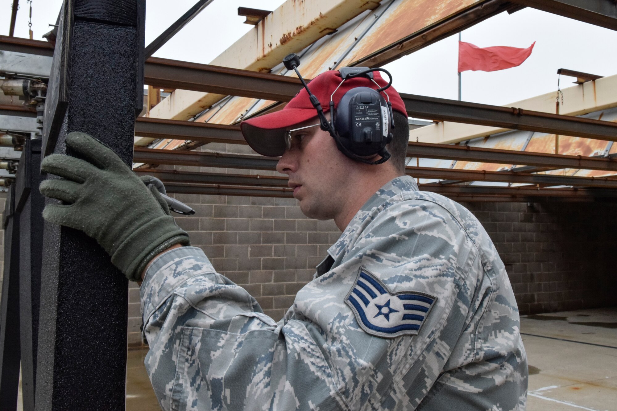 Staff Sgt. Greg Peterson, 72nd Security Forces Squadron combat arms instructor, tallies the score from hits on a silhouette target during a break in shooting at a pistol competition hosted by the 72 SFS in conjunction with Police Week 2016 activities on Tuesday May 17, 2016, Tinker Air Force Base, Okla. Peterson and other combatr arms instructors acted as safety observers and scorekeepers during the event which challenged shooters during both speed and accuracy events. (U.S. Air Force photo/Greg L. Davis)