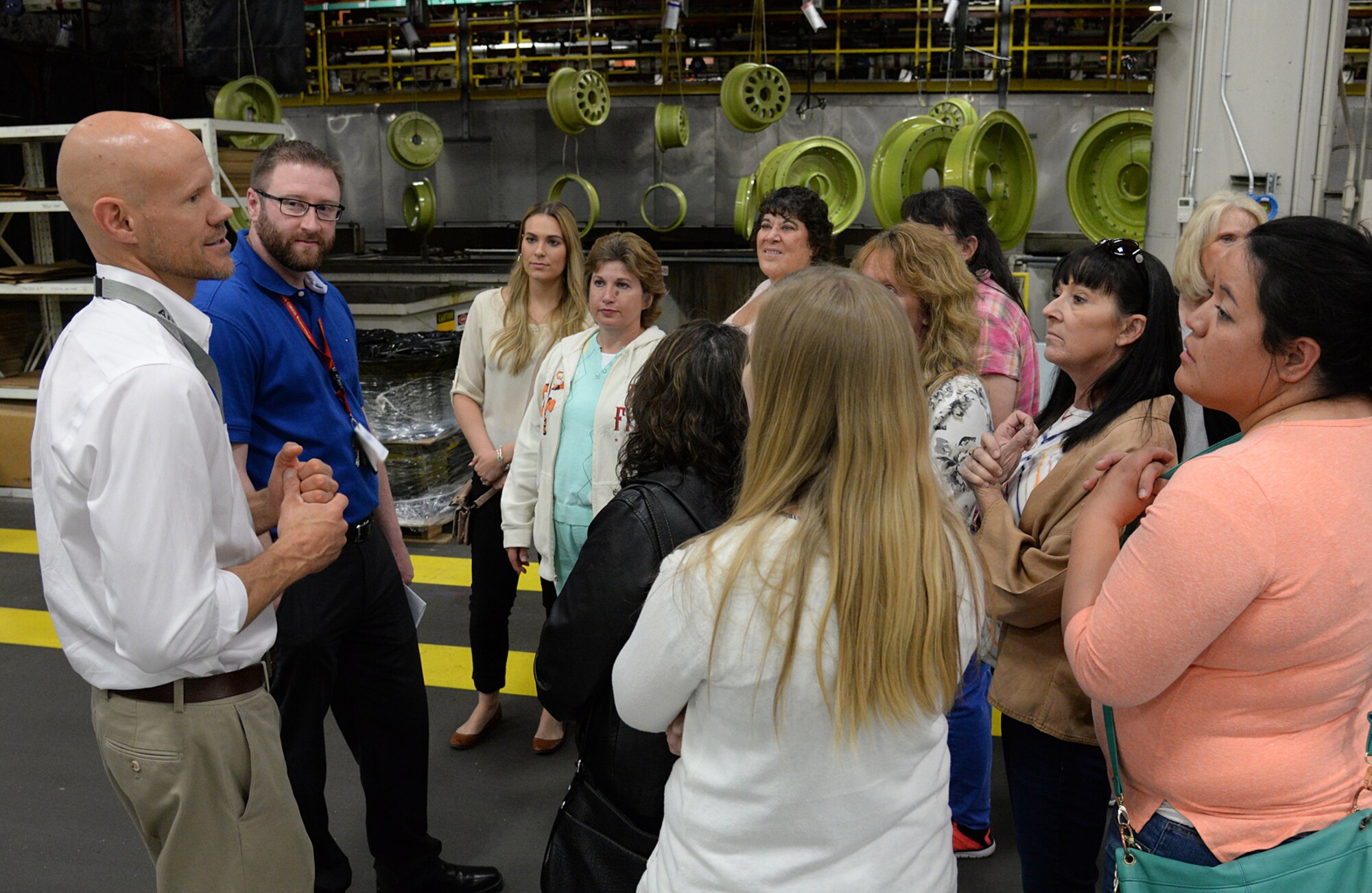 Nathan Hughes, lead process engineer (left) and Brett Luckett, process engineer, from 532nd Commodities Maintenance Squadron, discuss wheel and brake assemblies during the Team Hill spouses’ tour May 25 at Hill Air Force Base, Utah. The spouses were shown the start to finish process of disassembly to reassembly of aircraft wheels, brakes and landing gear from all types of Air Force aircraft.  (U.S. Air Force Photo by Alex R. Lloyd)