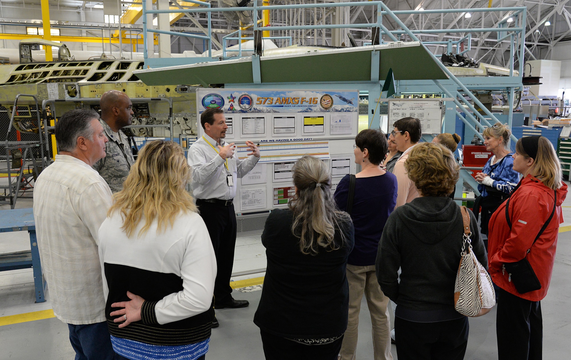 Brent Polglase, 573rd Aircraft Maintenance Squadron director, briefs a group of spouses during their visit to the F-16 Fighting Falcon production line May 25 at Hill Air Force Base, Utah. Polglase explained what it takes to perform depot maintenance and what impact it has on extending the service life of an F-16.  (U.S. Air Force Photo by Alex R. Lloyd)
