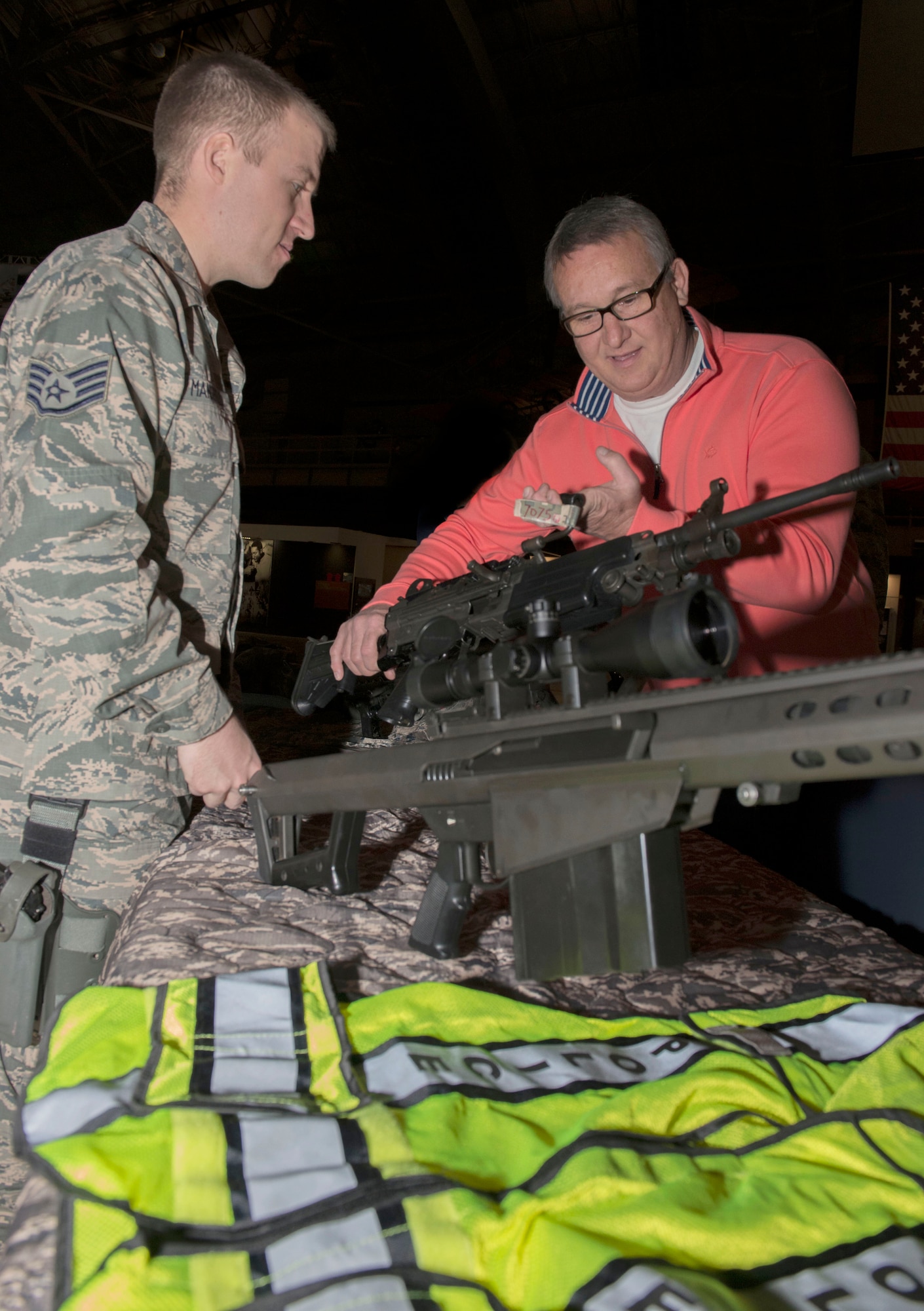 Staff Sgt. Cameron Mansfield, 88th Security Forces Squadron Installation Combat Arms Instructor, shows a static weapons display to James Mann, who visited the National Museum of the U.S. Air Force during National Police Week . (U.S. Air Force photo/Michelle Gigante)