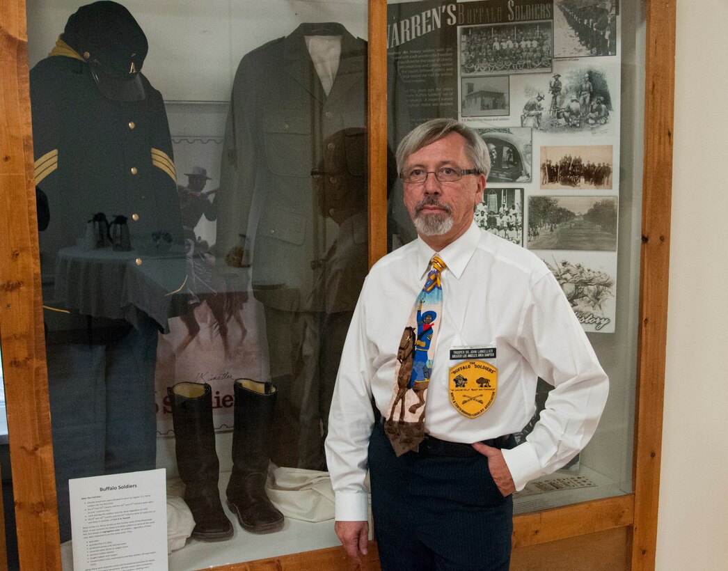 John Langellier, Ph.D., consulting historian, poses in the Warren ICBM & Heritage Museum on F.E. Warren Air Force Base, Wyo., June 1, 2016, in front of a display case housing Buffalo Soldier artifacts such as uniform items and photographs. (U.S. Air Force photo by Senior Airman Jason Wiese)