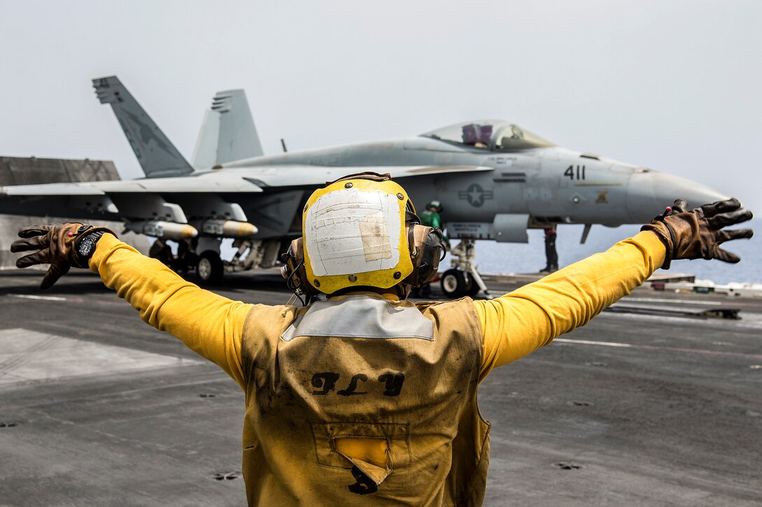 Navy Petty Officer 3rd Class Raimon Hubbard directs an F/A-18E Super Hornet on the flight deck of the aircraft carrier USS Harry S. Truman in the Mediterranean Sea, June 3, 2016. The USS Truman and its Carrier Strike Group are supporting Operation Inherent Resolve, maritime security operations and theater security cooperation efforts in the U.S. 6th Fleet area of operations. The Hornet is assigned to Strike Fighter Squadron 25. Navy photo by Petty Officer 3rd Class Anthony Flynn