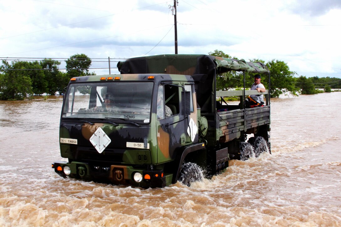 Soldiers drive a vehicle carrying first responders who are searching for residents during severe flooding in Rosenberg, Texas, June 2, 2016. Texas Army National Guard photo by Staff Sgt. Timothy Pruitt