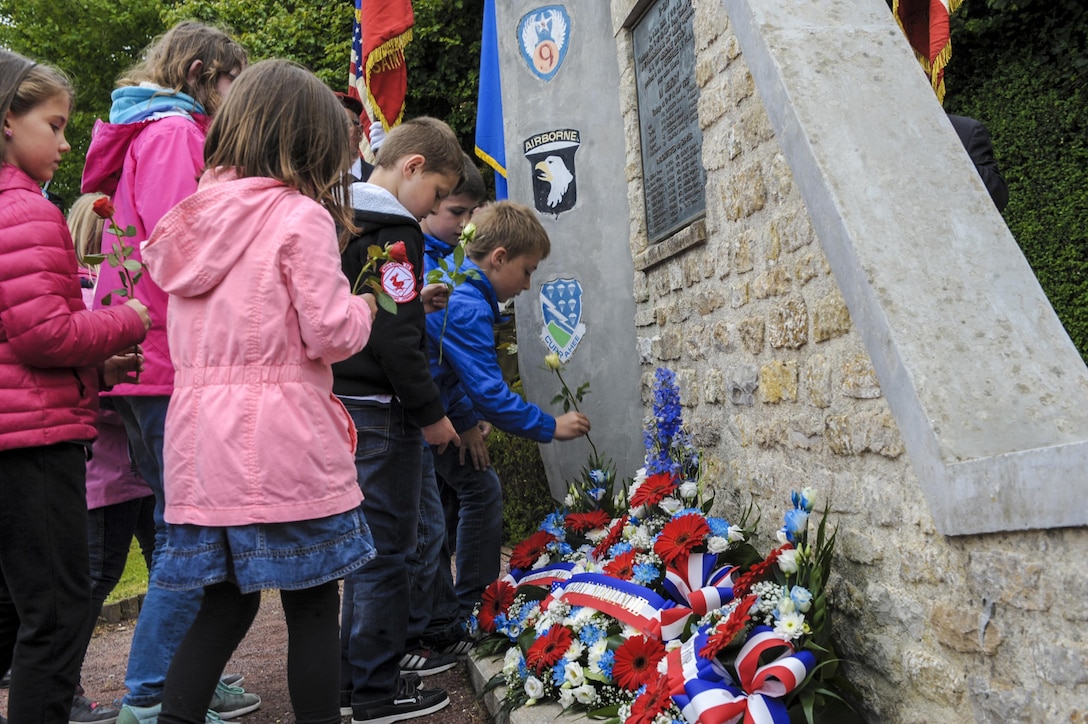 French children place flowers at the Currahee Memorial in Beuzeville au Plain, France, June 1, 2016. More than 380 service members from Europe and affiliated D-Day historical units are participating in the events commemorating the  72nd anniversary of D-Day. Air Force photo by Staff Sgt. Timothy Moore